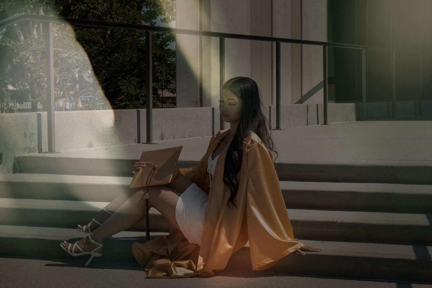 Person in casual attire sitting on concrete steps in moody lighting creates atmospheric scene.