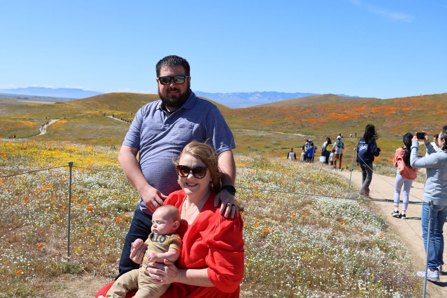 Visitors enjoying the colorful wildflower blooms during superbloom season at Antelope Valley California Poppy Reserve.