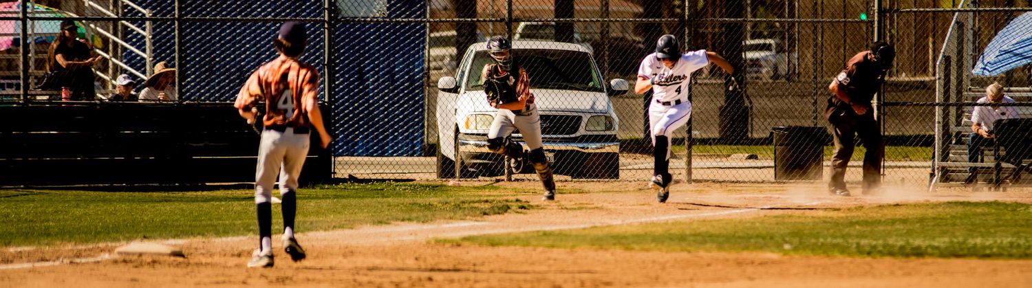 Baseball players in action on a dusty baseball diamond during a game.