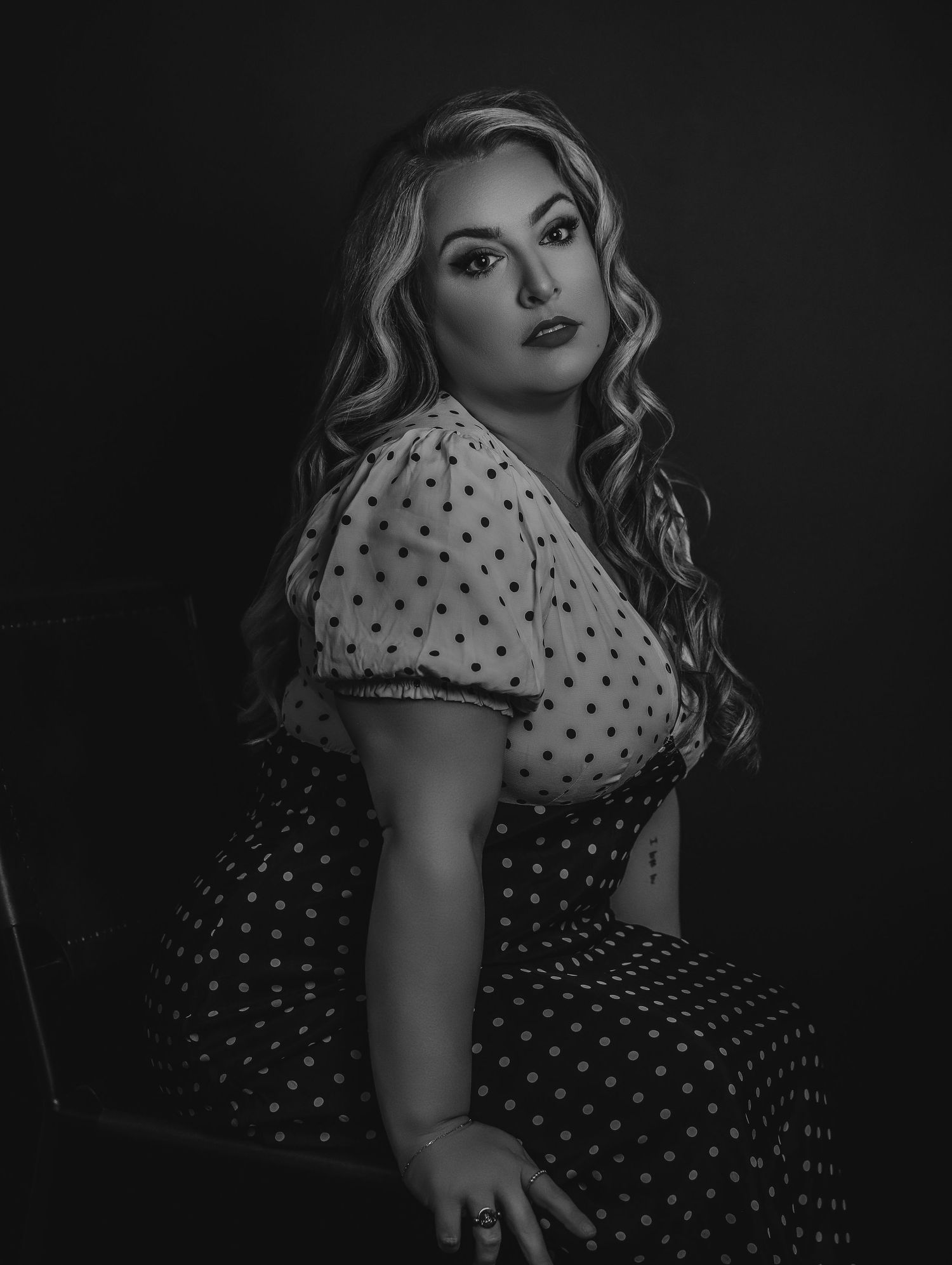 Dramatic black and white portrait in Old Hollywood style of beautiful young blonde woman in polka dot dress for Boudoir by Bri in St. Louis
