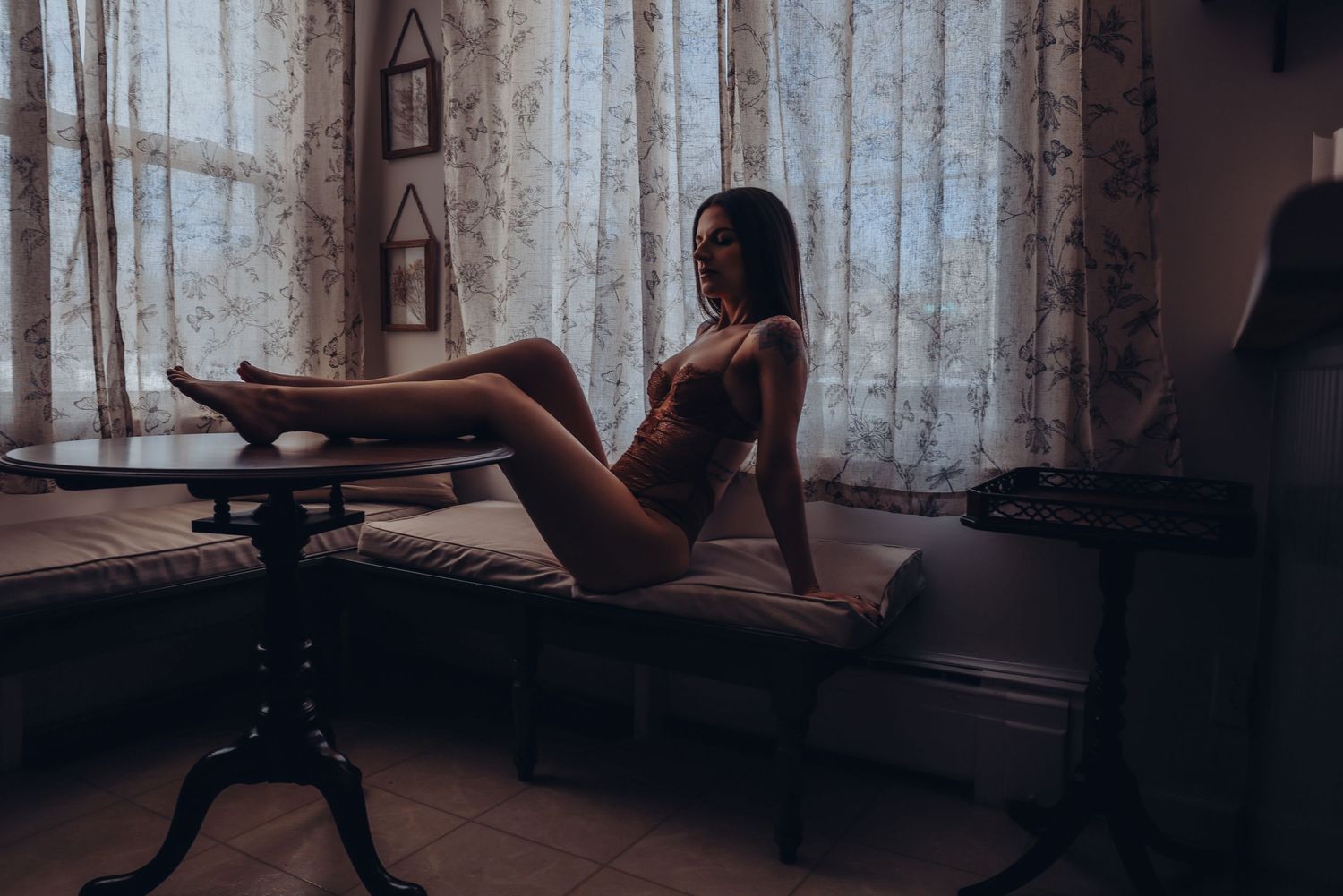 Romantic dimly lit cozy kitchen breakfast nook woman in lingerie posing boudoir photoshoot session boudoir by bri saint Louis Missouri