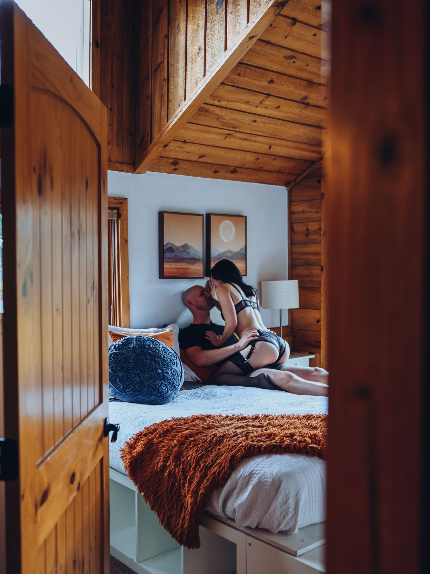 A couple posing in mountain cabin bedroom boudoir photoshoot for Boudoir by Bri Saint Louis