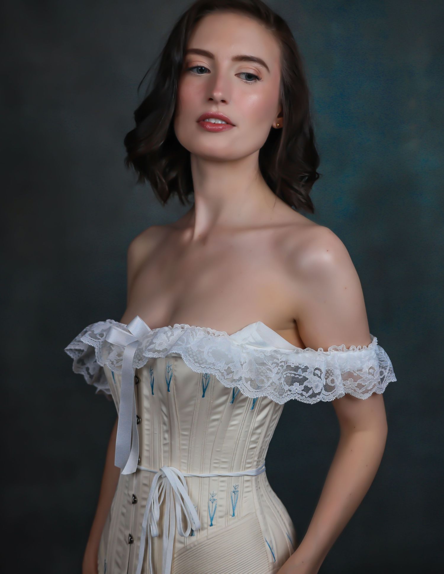 Painting-like portrait of beautiful young woman with short hair in white vintage corset for photoshoot with Boudoir by Bri in Saint Louis