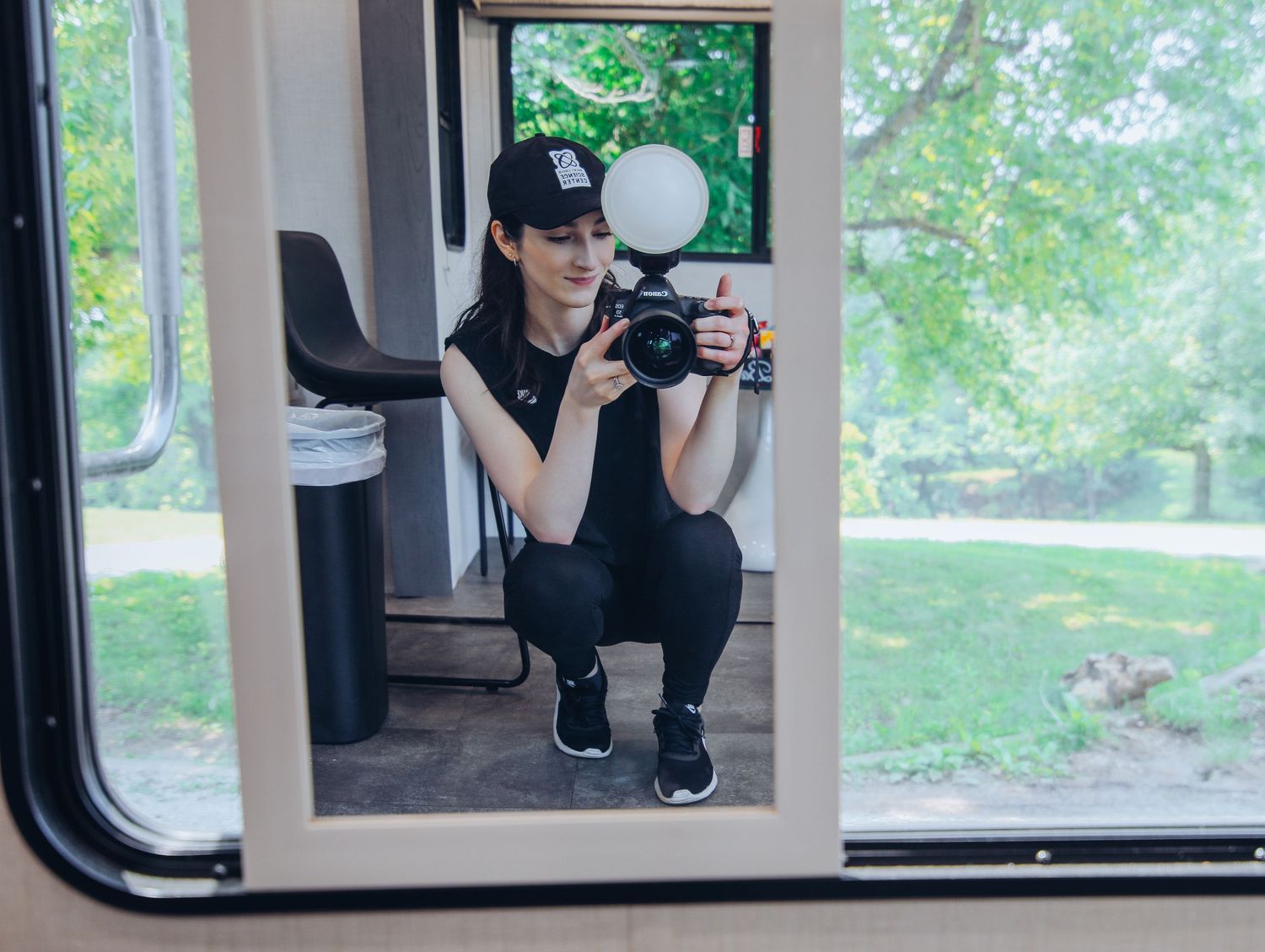 Woman photographer squatting and taking a selfie with professional camera in mirror on set for photoshoot in Saint Louis for Boudoir by Bri