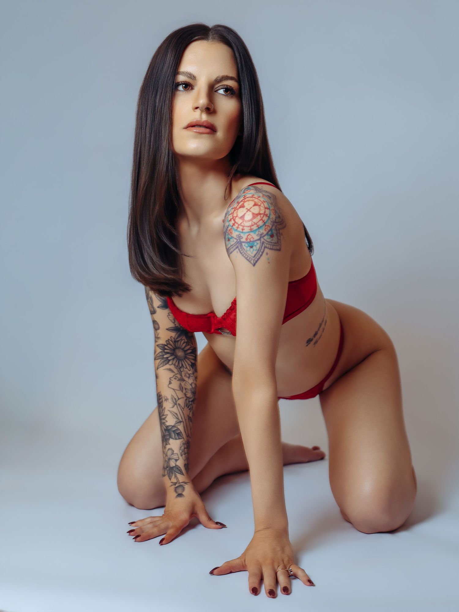 Sexy boudoir photoshoot portraits with Boudoir by Bri in Saint Louis Missouri Studio woman posing in red lingerie on white background