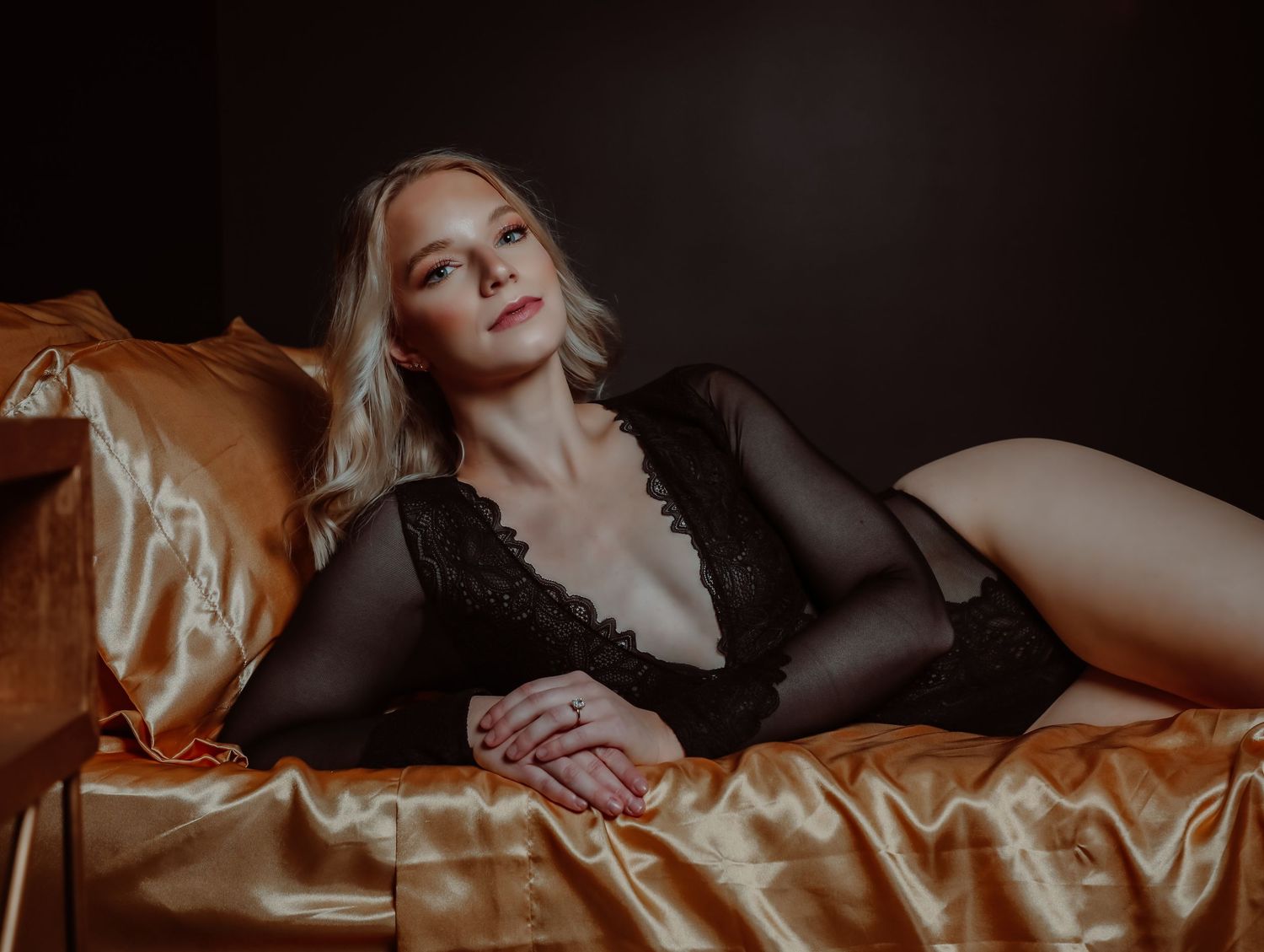 Posing in black lingerie on gold satin sheets in studio for photoshoot with Boudoir by Bri in Saint Louis Missouri