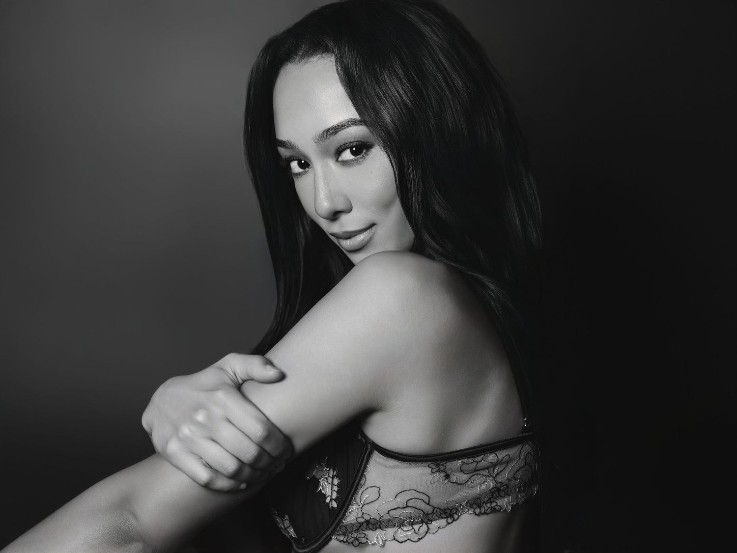 Beautiful portrait in black and white of young woman in lingerie looking at camera over her shoulder for Boudoir by Bri in St. Louis MO