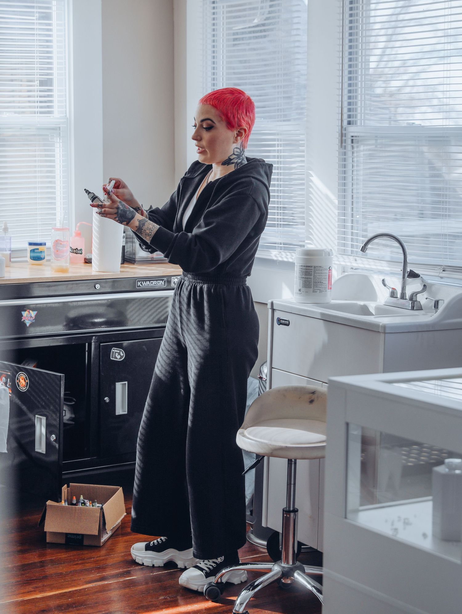 Boudoir by Bri photoshoot of small business branding and headshots for tattoo artist with pink hair in black jumpsuit in St. Louis, MO