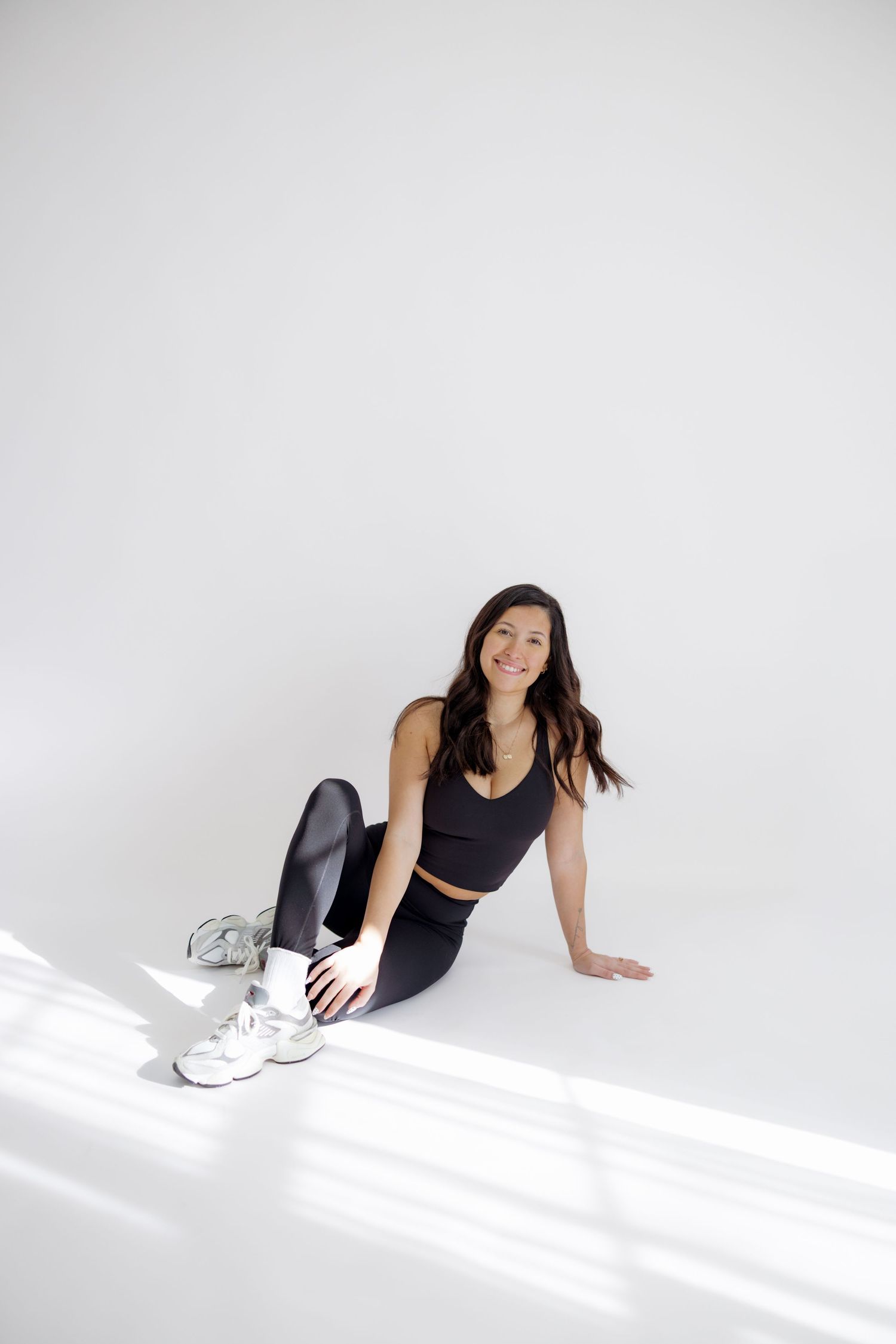 Athletic figure in black workout attire performs dynamic floor exercises against white background in sequence.