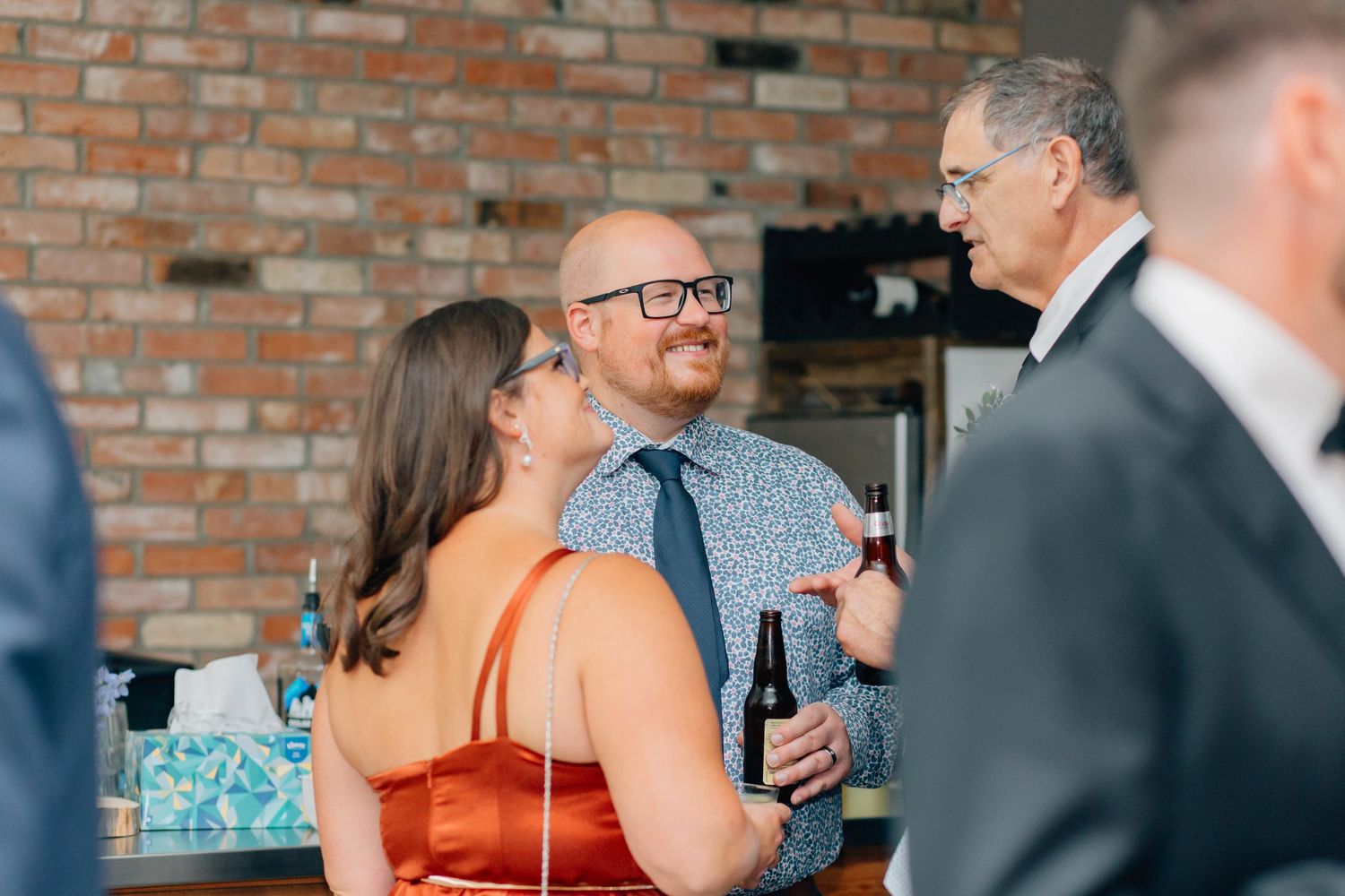 Wedding guests socializing and laughing at a wedding reception.