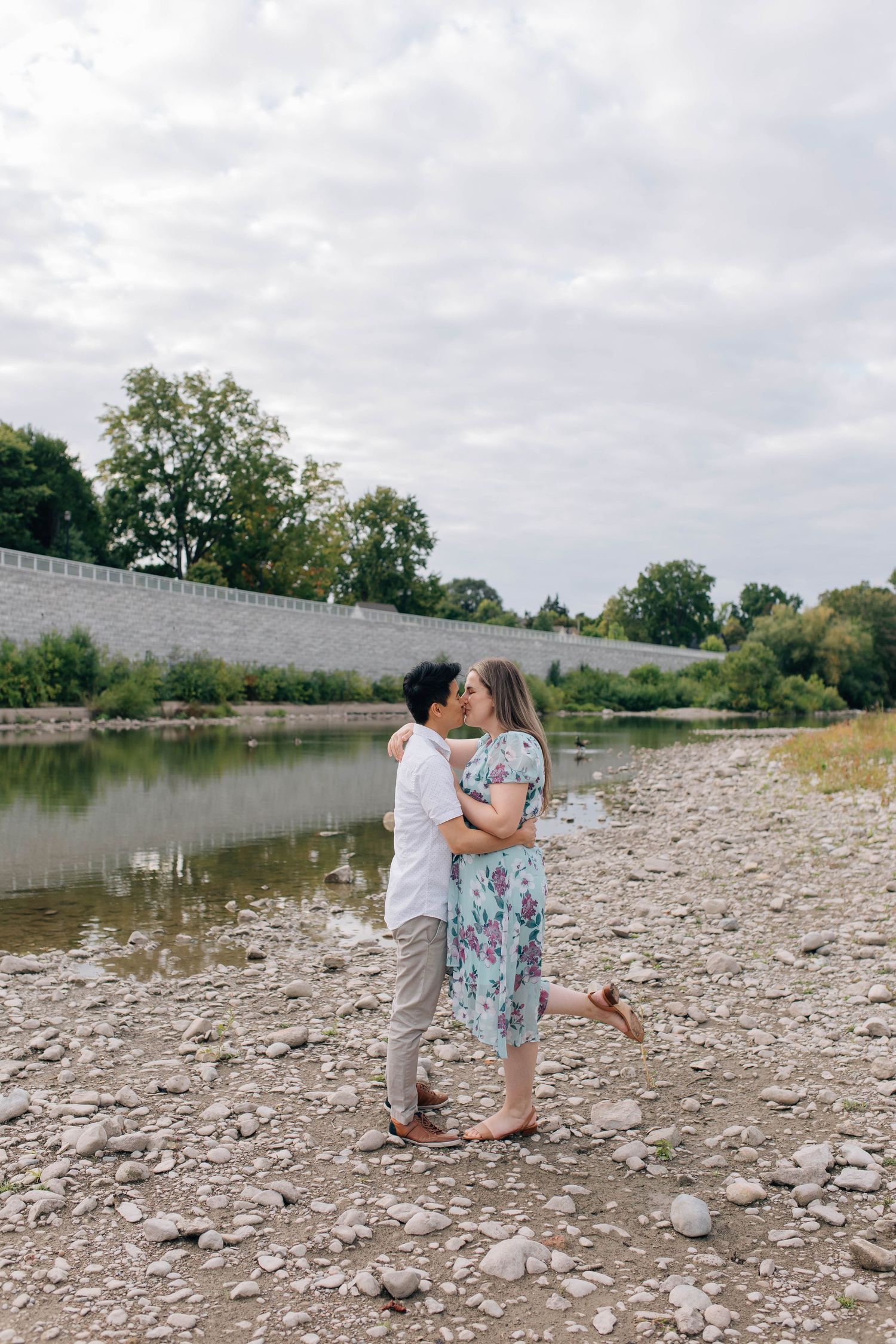 couple kissing by the water at Harris park in london ontario