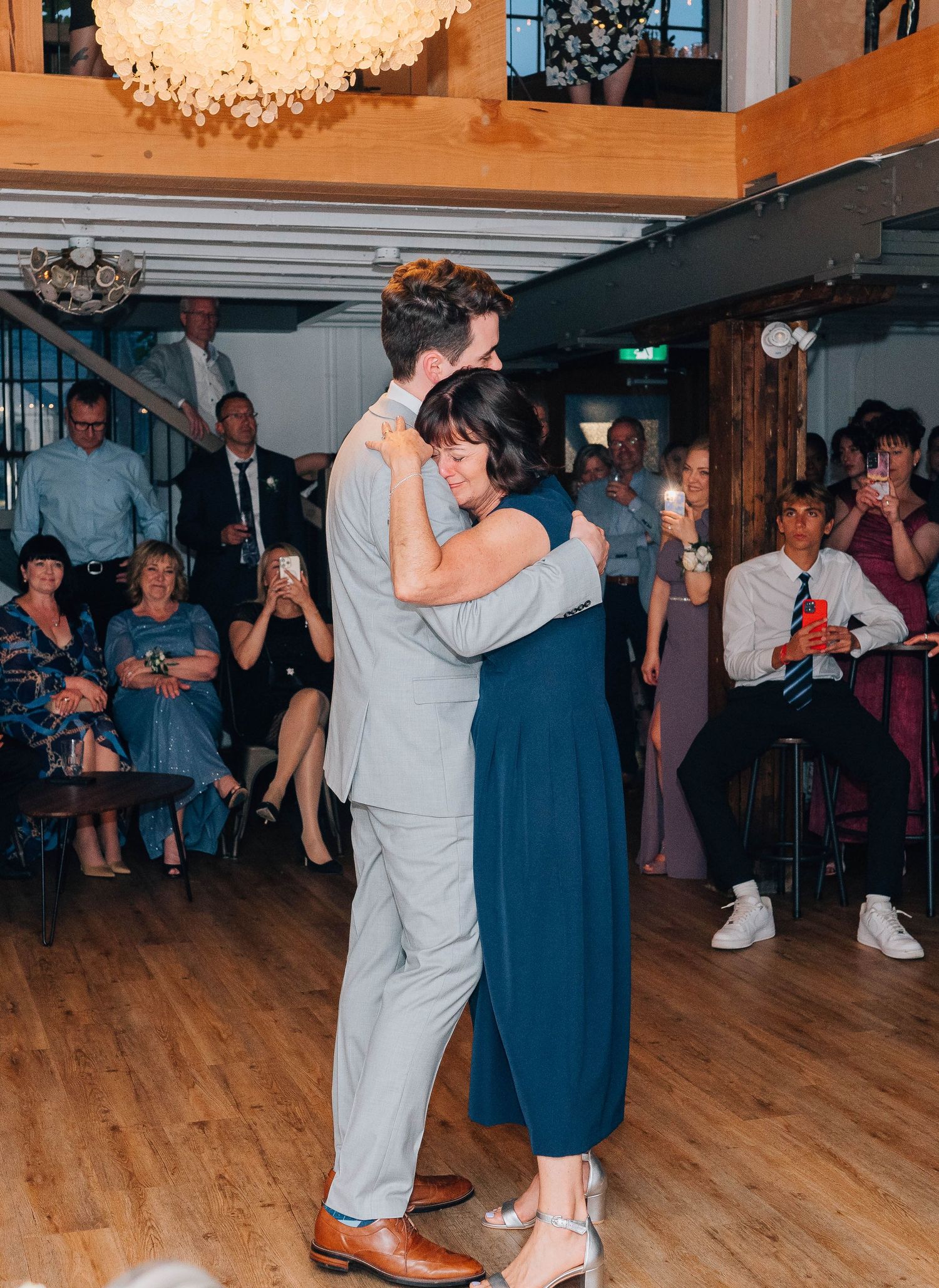 A couple shares an intimate first dance at their wedding reception while guests watch and celebrate.