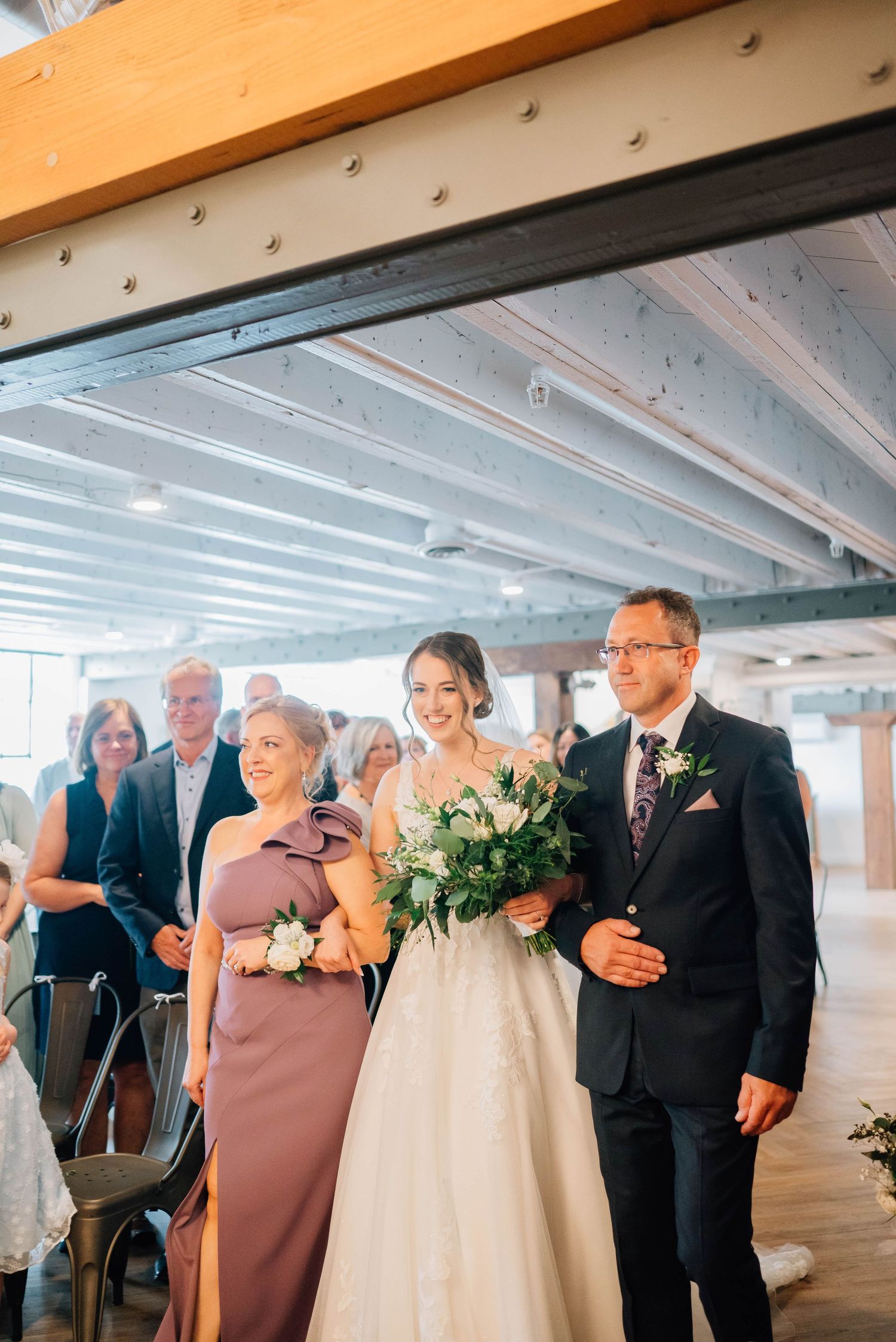 Bride walking down the aisle with her parents at the Timber Barn in St. Jacob's Ontario