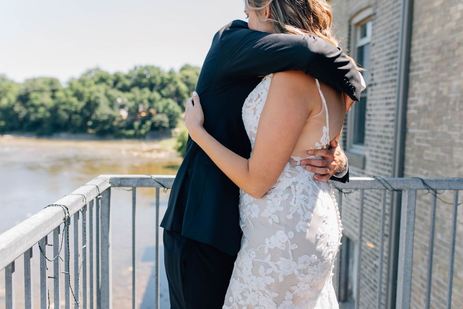 Bride and groom sharing an emotional embrace on outdoor balcony during first look.