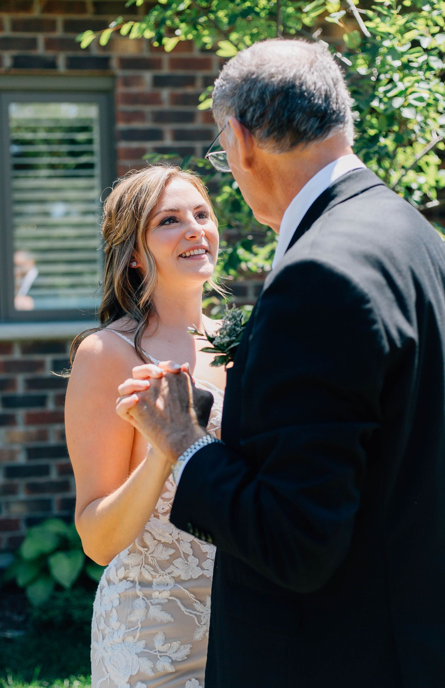 Bride smiling at father during an outdoor first look moment before the wedding ceremony.