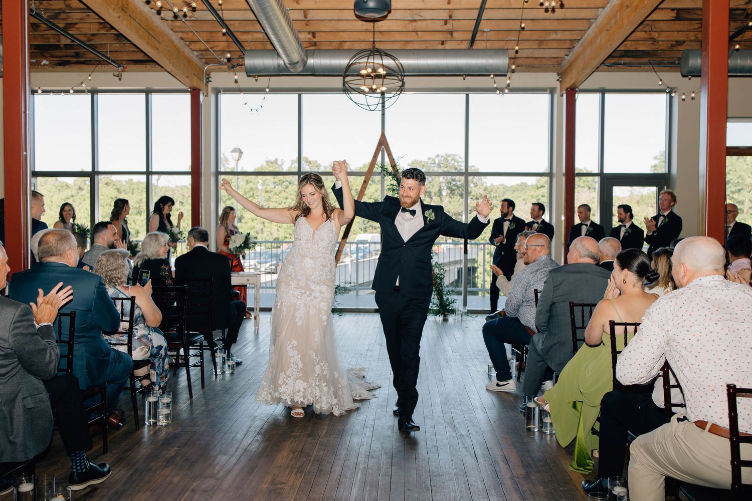 Bride and groom excitedly walk down the aisle after getting married at Rivers Edge at the Arlington in Paris Ontario.
