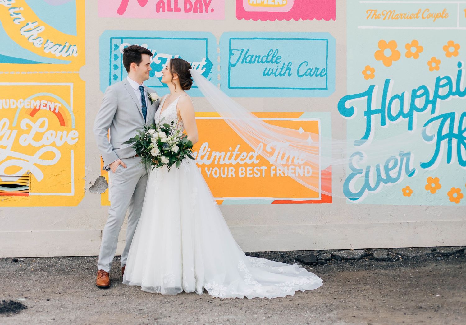 Bride and Groom standing in front of mural in St. Jacob's Ontario