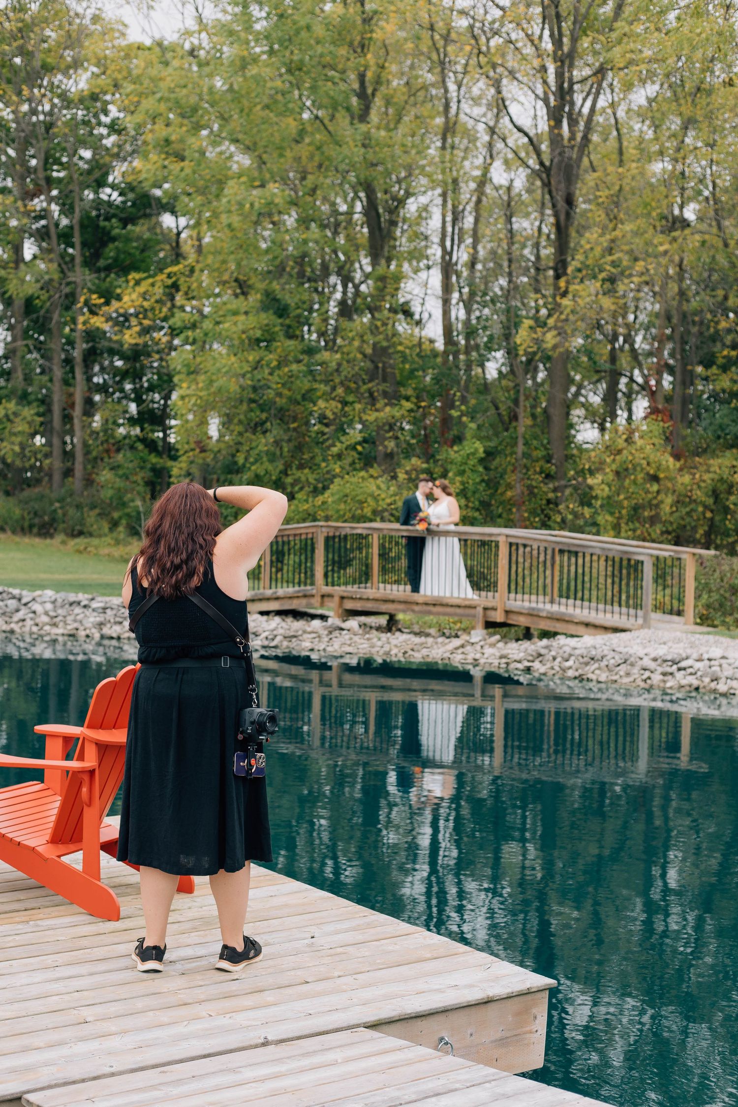 Woodstock Ontario wedding photographer taking a picture of a wedding couple from across the pond at a wedding.