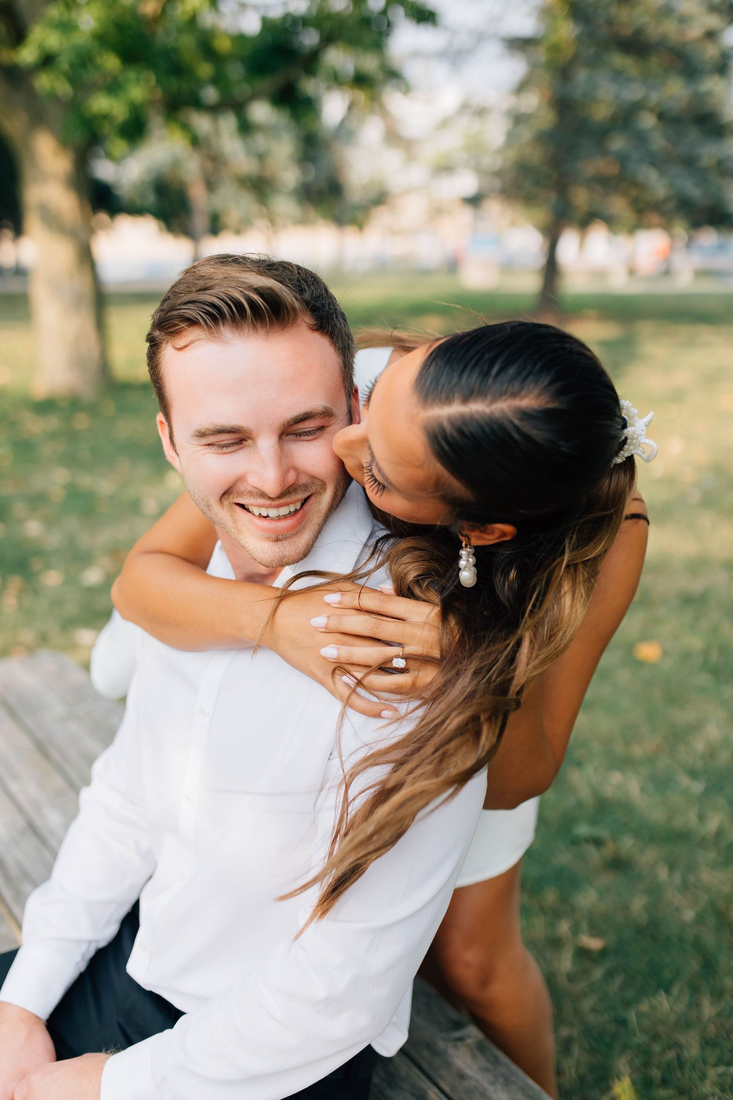 Woman kissing mans cheek during engagement session in London Ontario