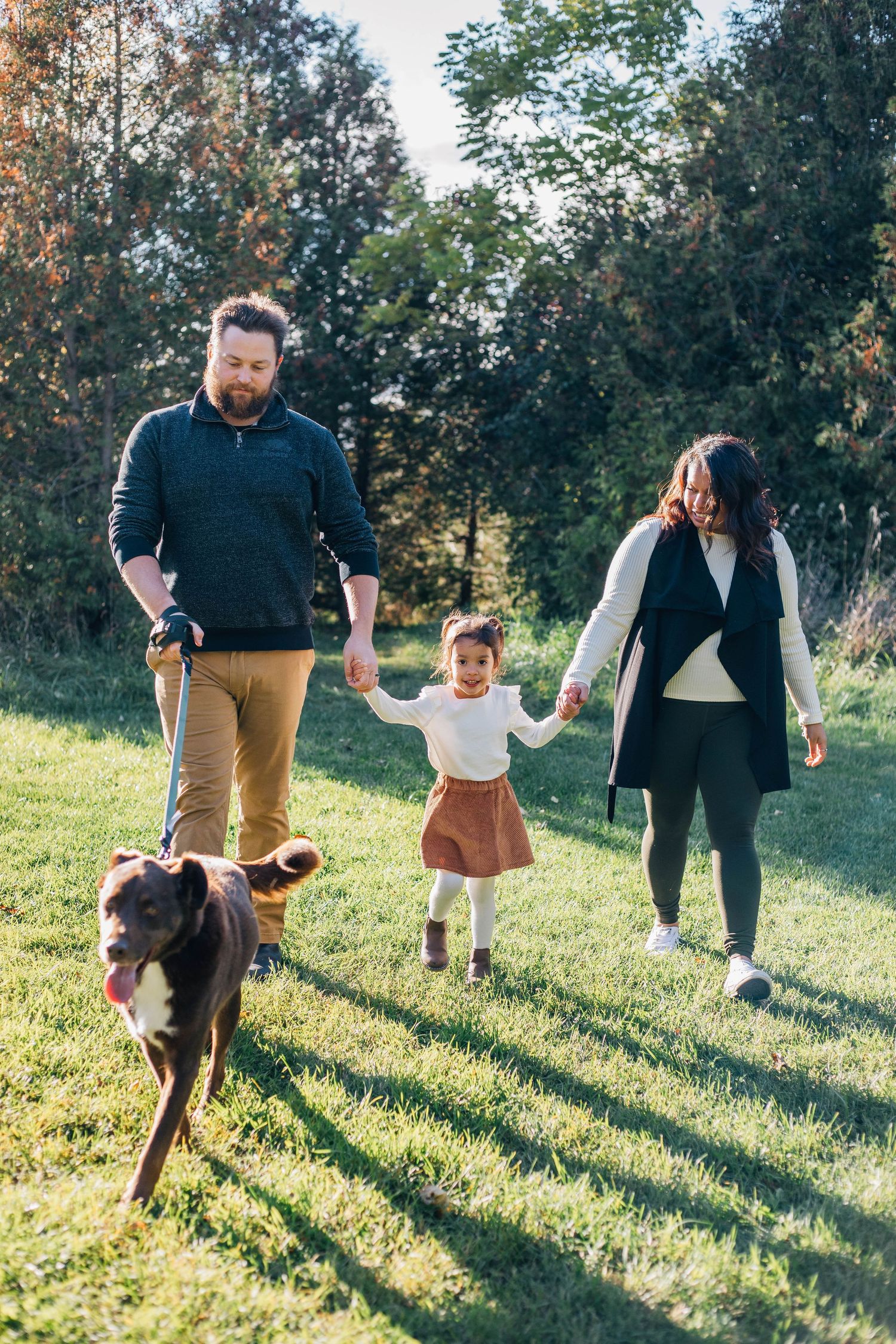 Family walking together with their dog on a fall day in Stratford Ontario