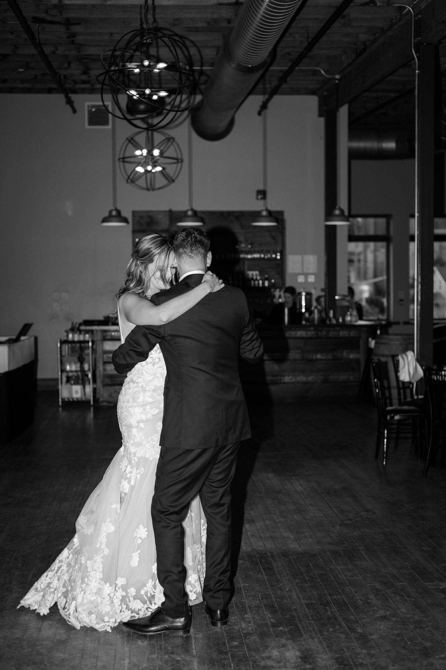 Black and white photo of bride and groom embracing during intimate first dance at wedding reception in Paris Ontario.