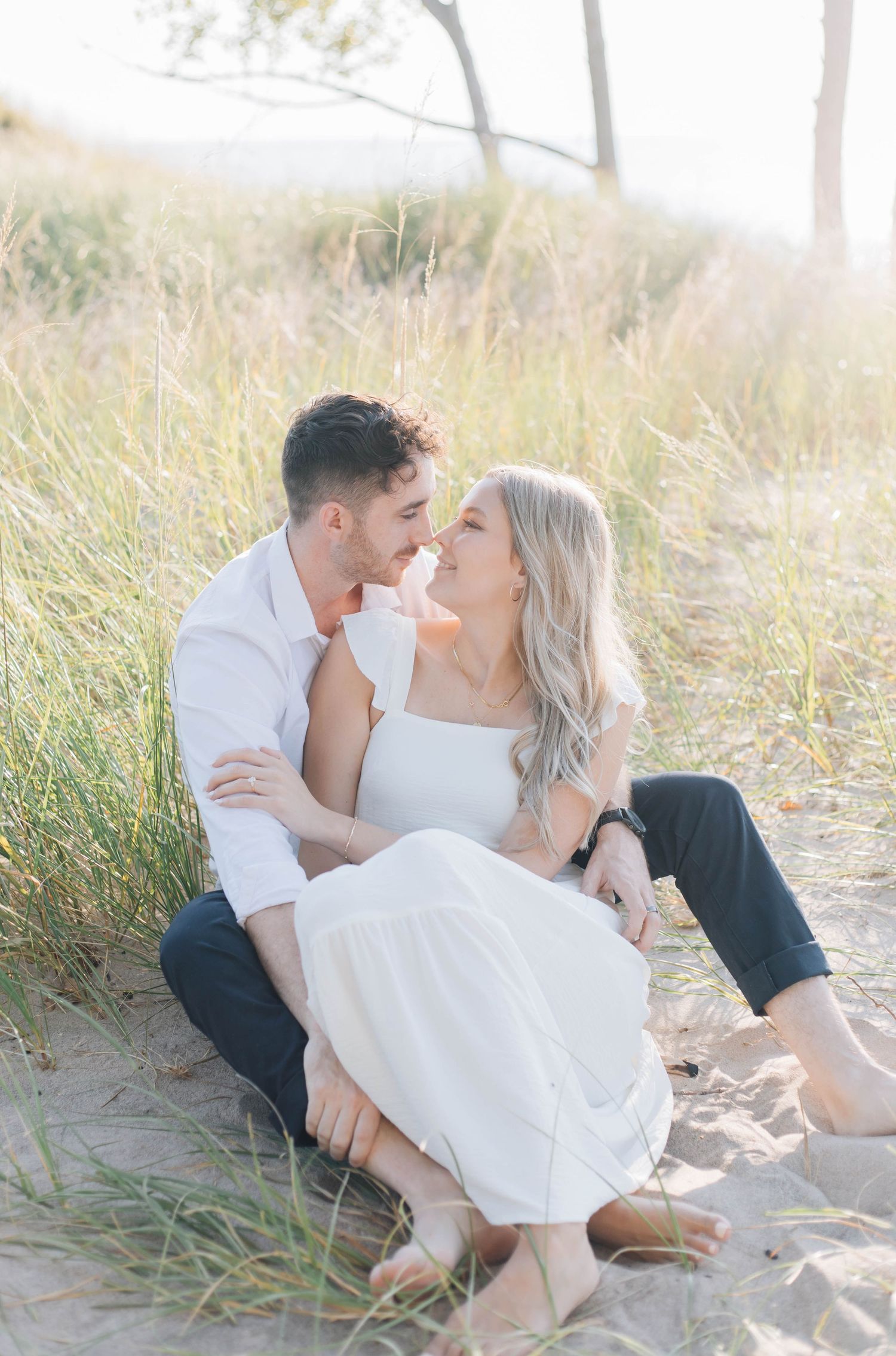 Couple snuggling up close at Pinery Provincial Park and sitting on the beach.