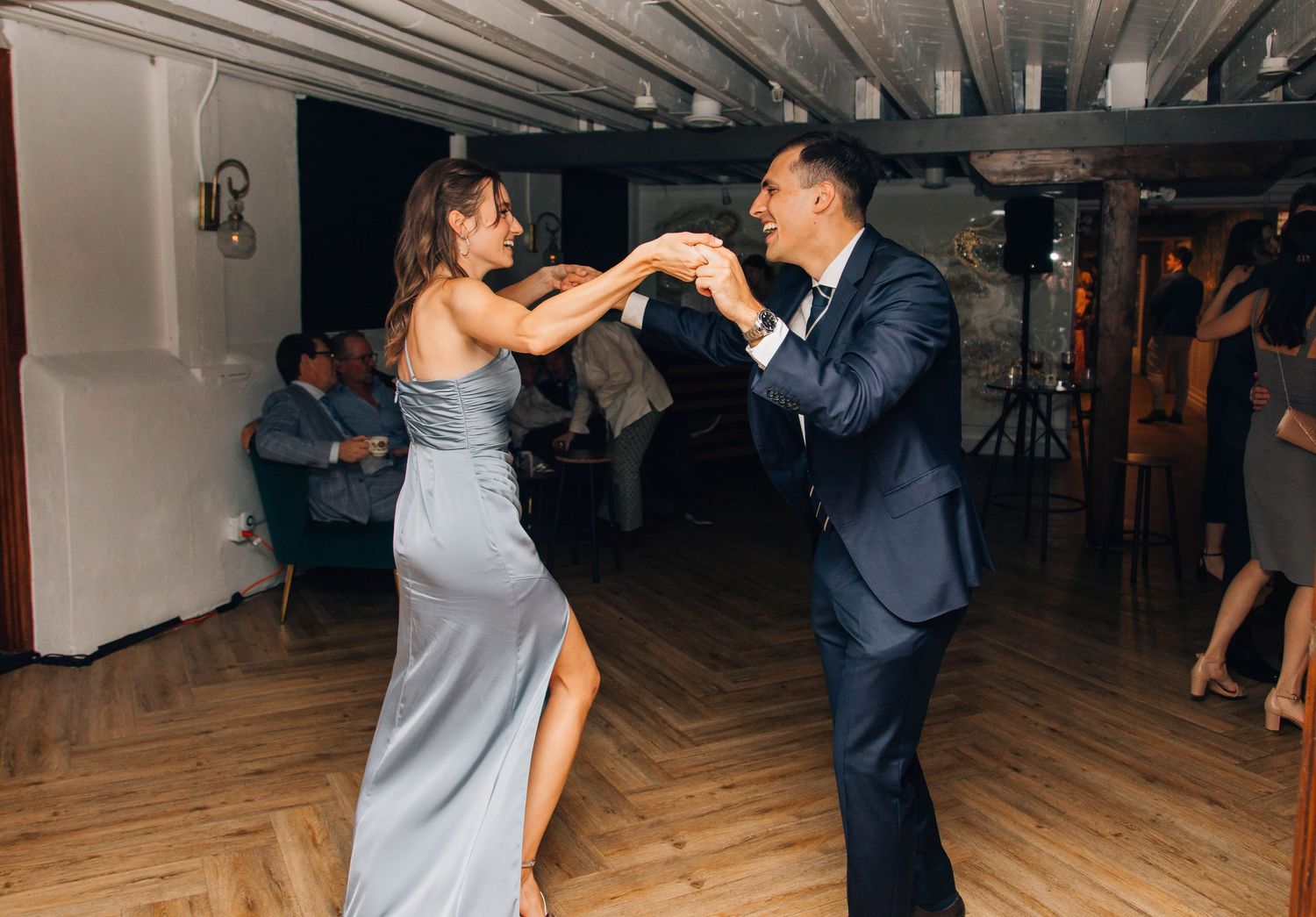 Couple in elegant attire dance gracefully together at a wedding reception.