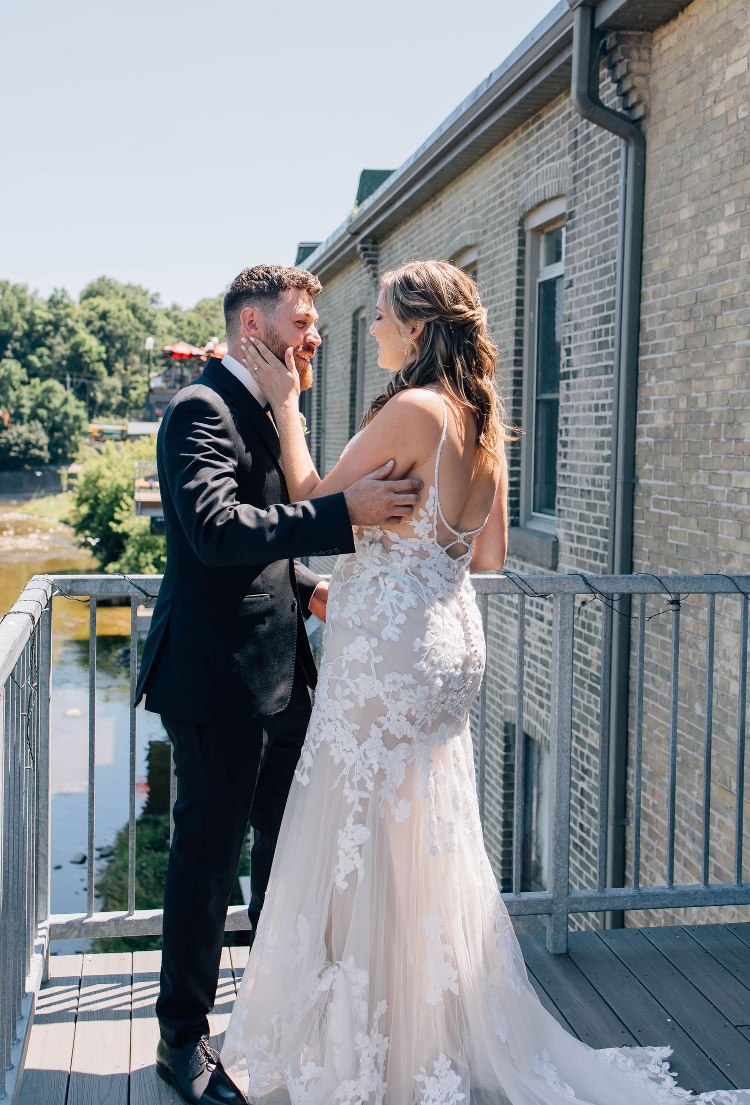 Groom emotional as bride tenderly touches his face during outdoor first look moment.