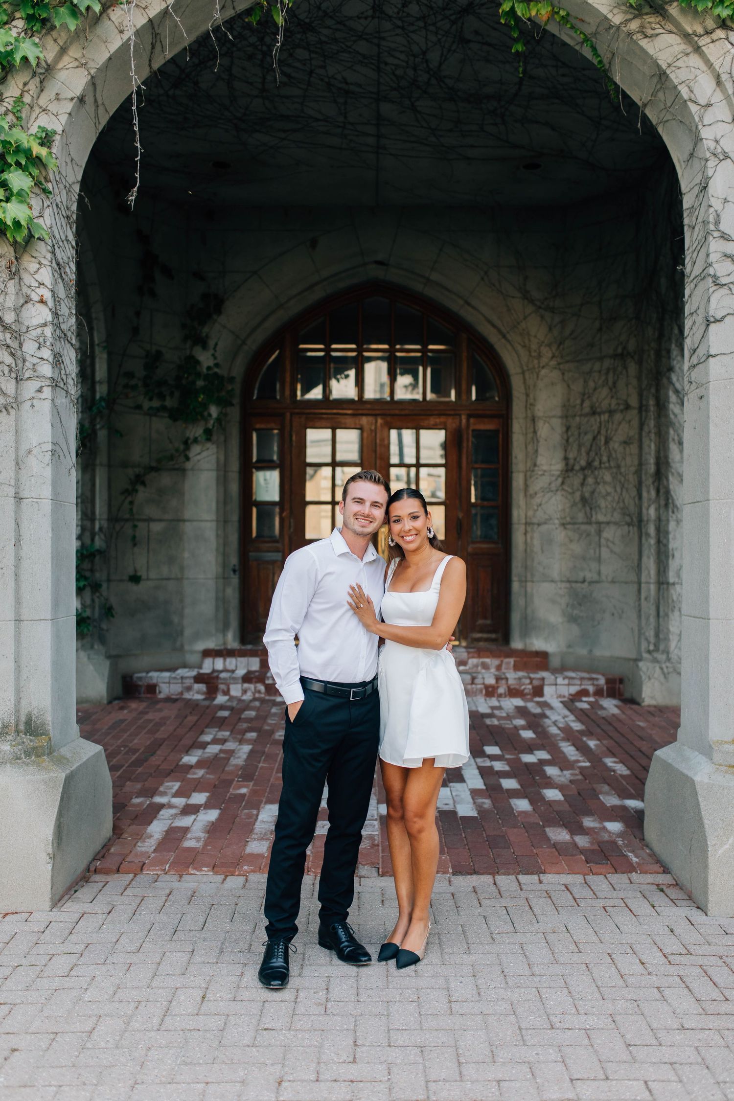 Bride and groom smiling at the camera in front of the Old Courthouse in London Ontario