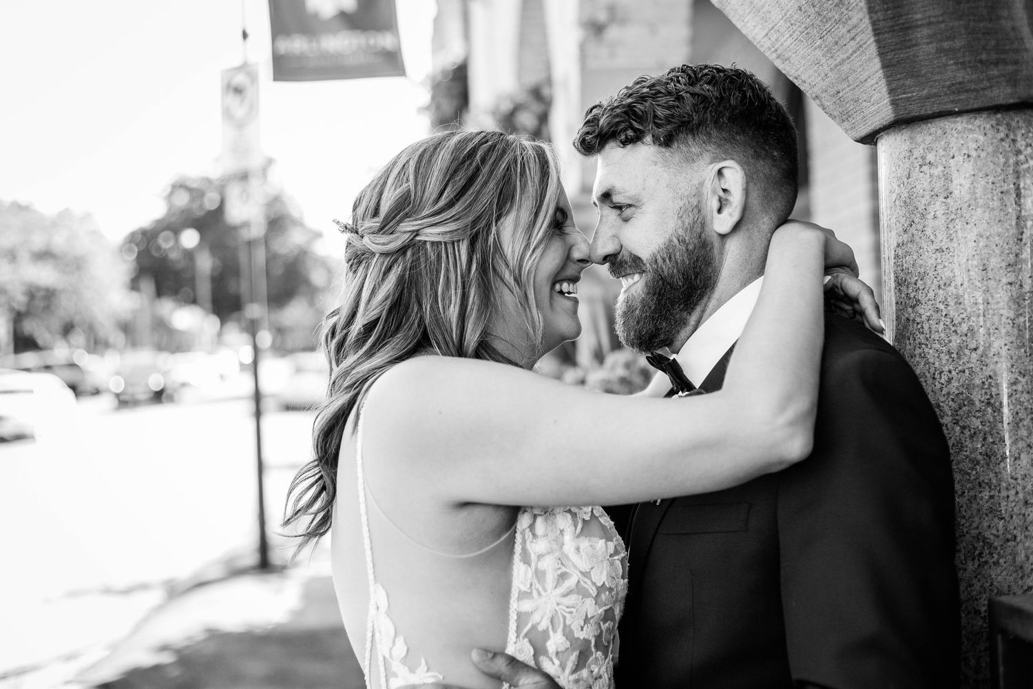 Black and white photo of a bride and a groom sharing an intimate moment on a city street in Paris Ontario.