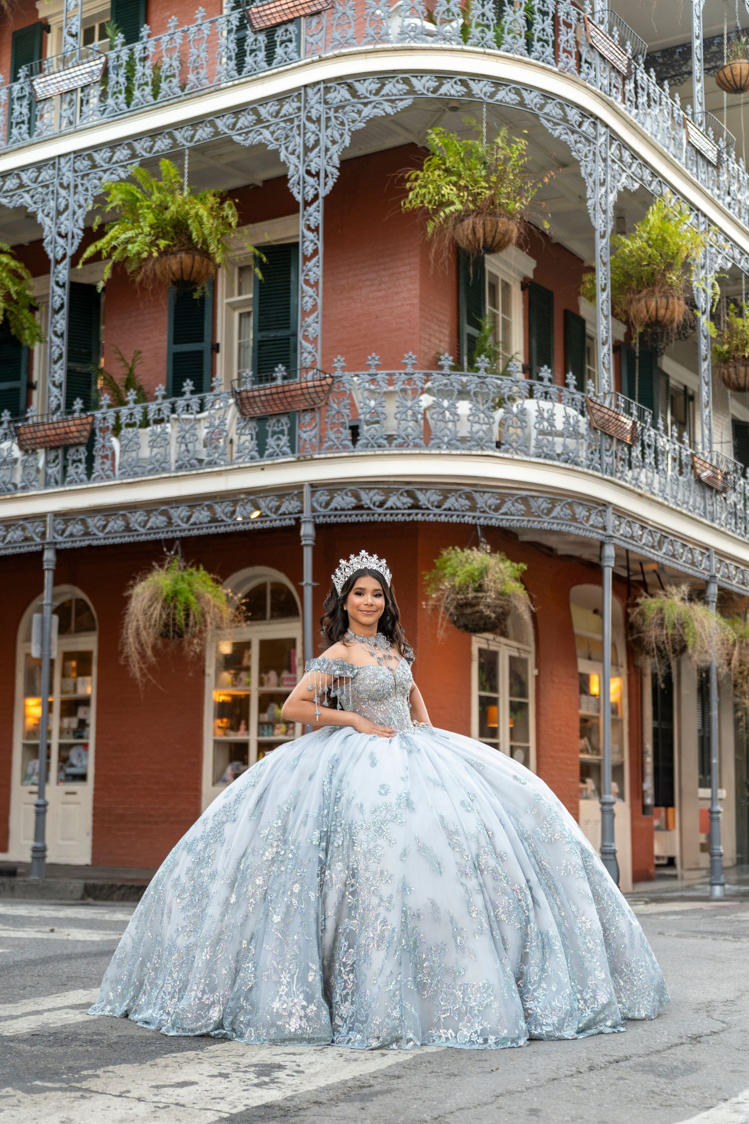 Young woman in a light blue quinceañera ball gown and tiara posing in New Orleans French Quarter.