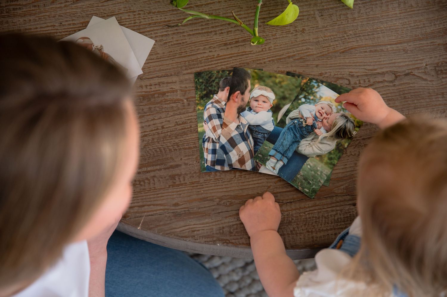 A person's hands sort through trading cards on a dark wooden table surface.