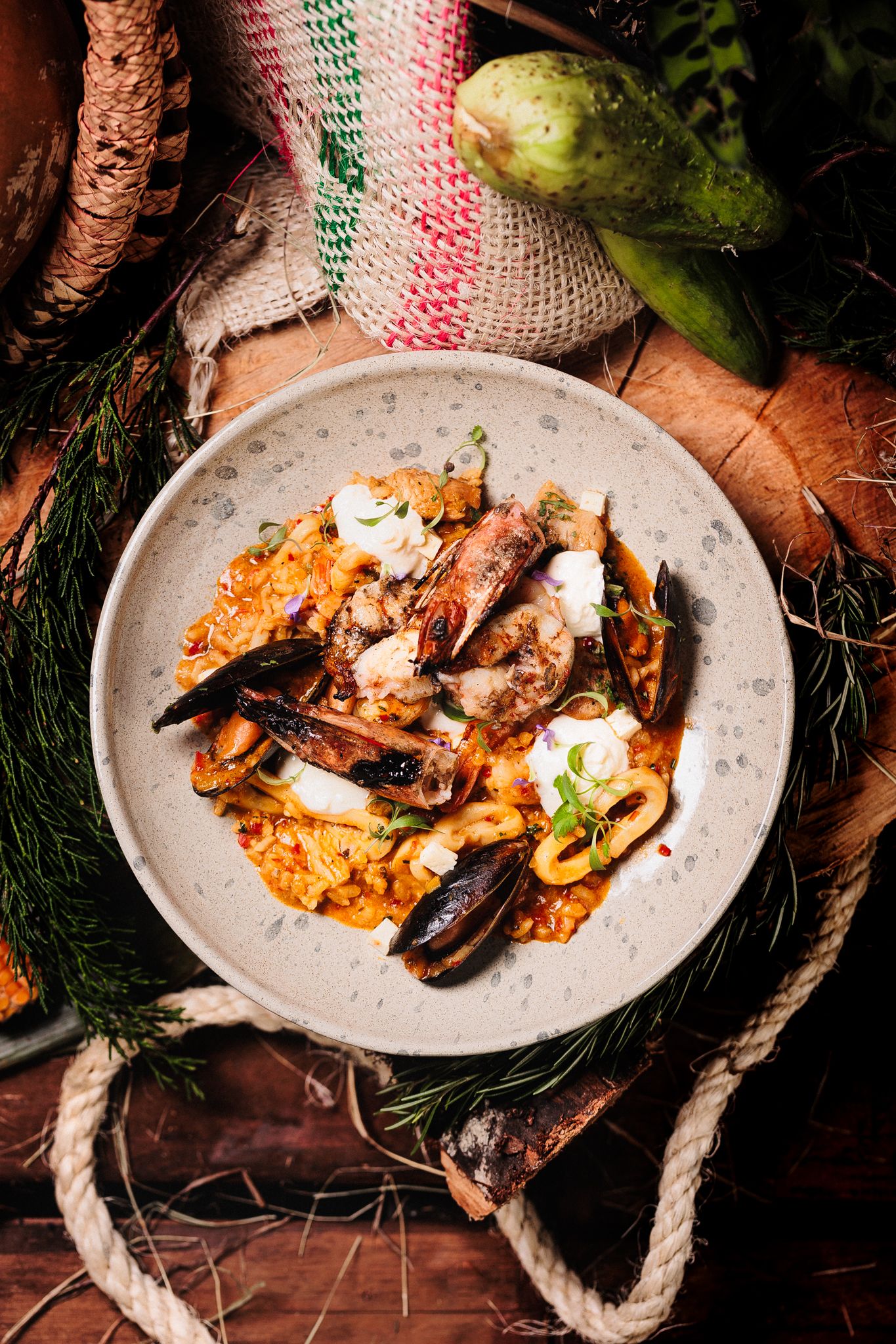 Grilled octopus with red sauce and fresh herbs served on rustic ceramic plates with rope garnish.