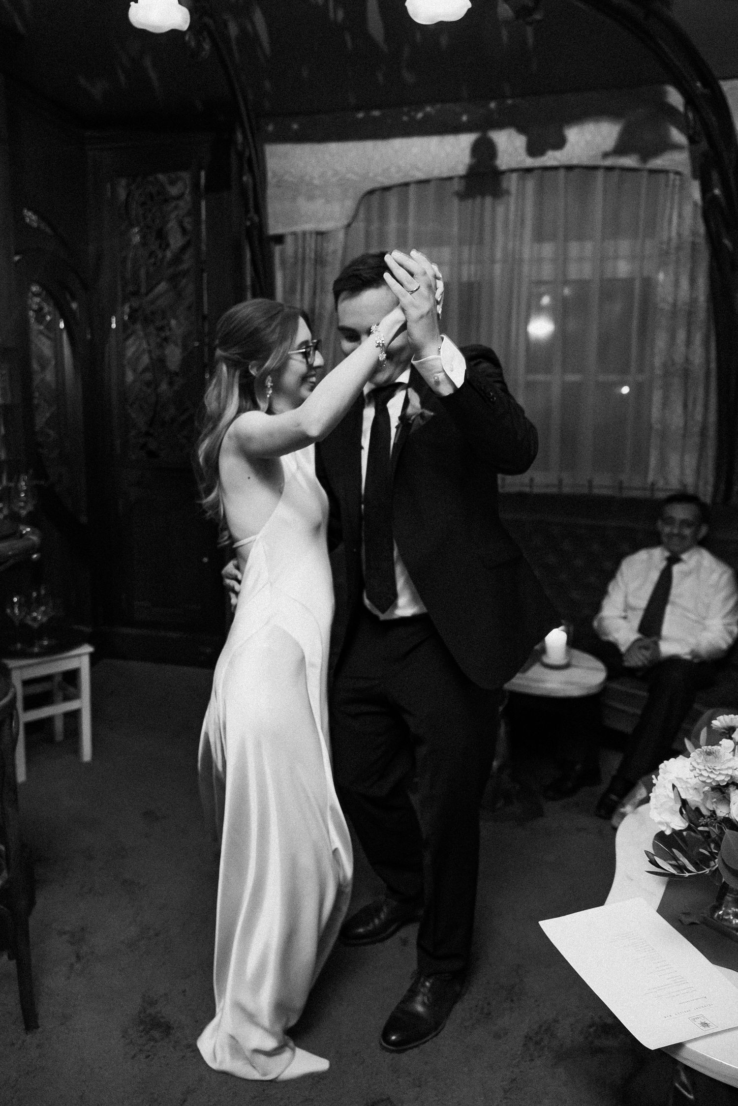 Bride and groom share their first dance in elegant black and white wedding reception photograph.