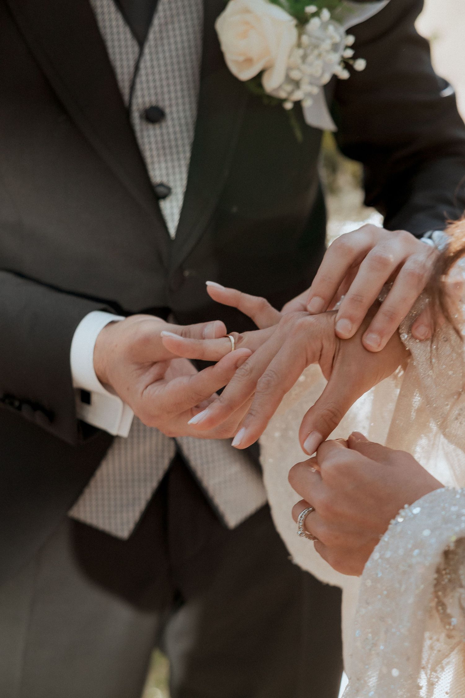 Close-up of bride and groom exchanging wedding rings during the ceremony.