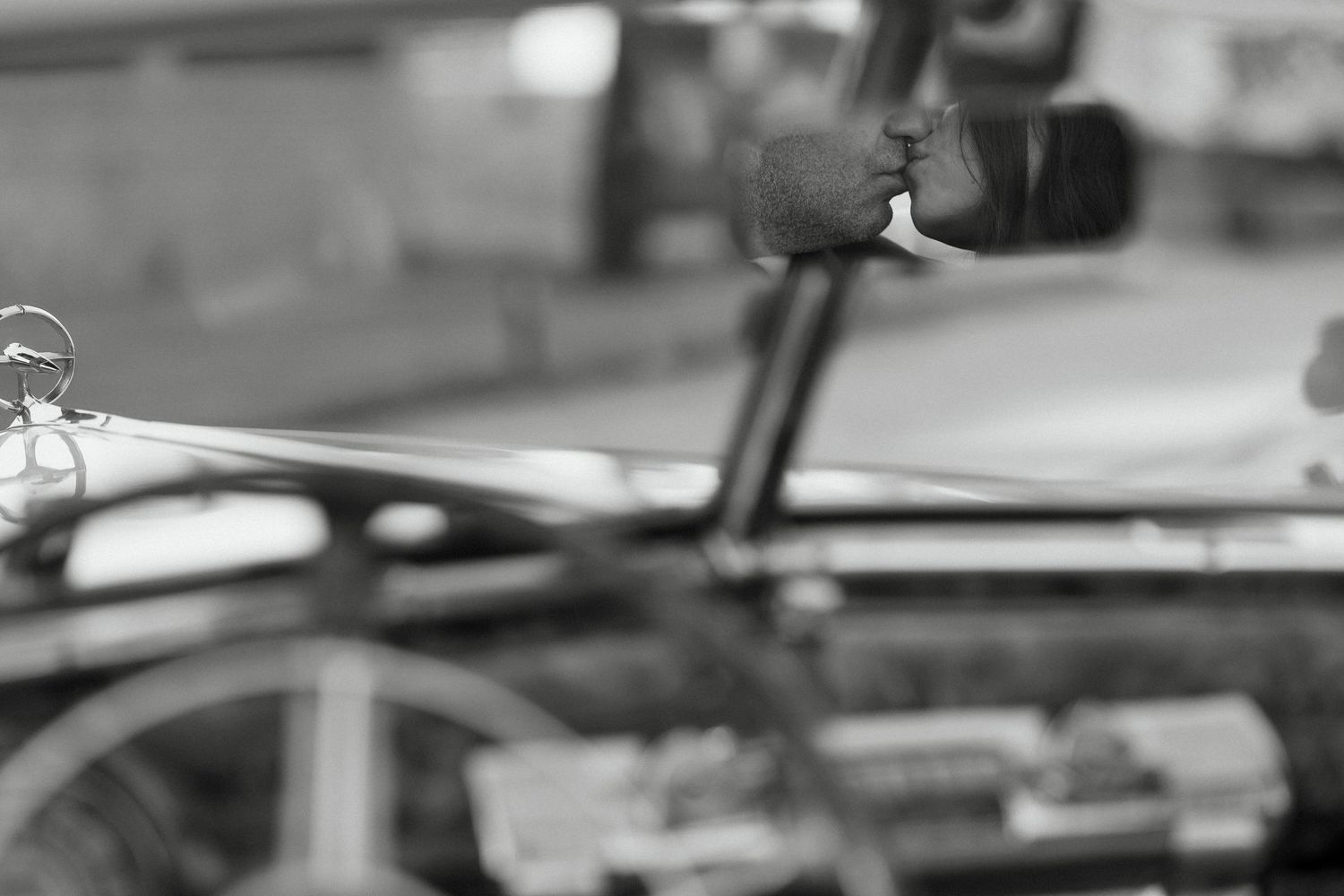 Black and white close-up of a trombone slide and mouthpiece in a blurred industrial setting.