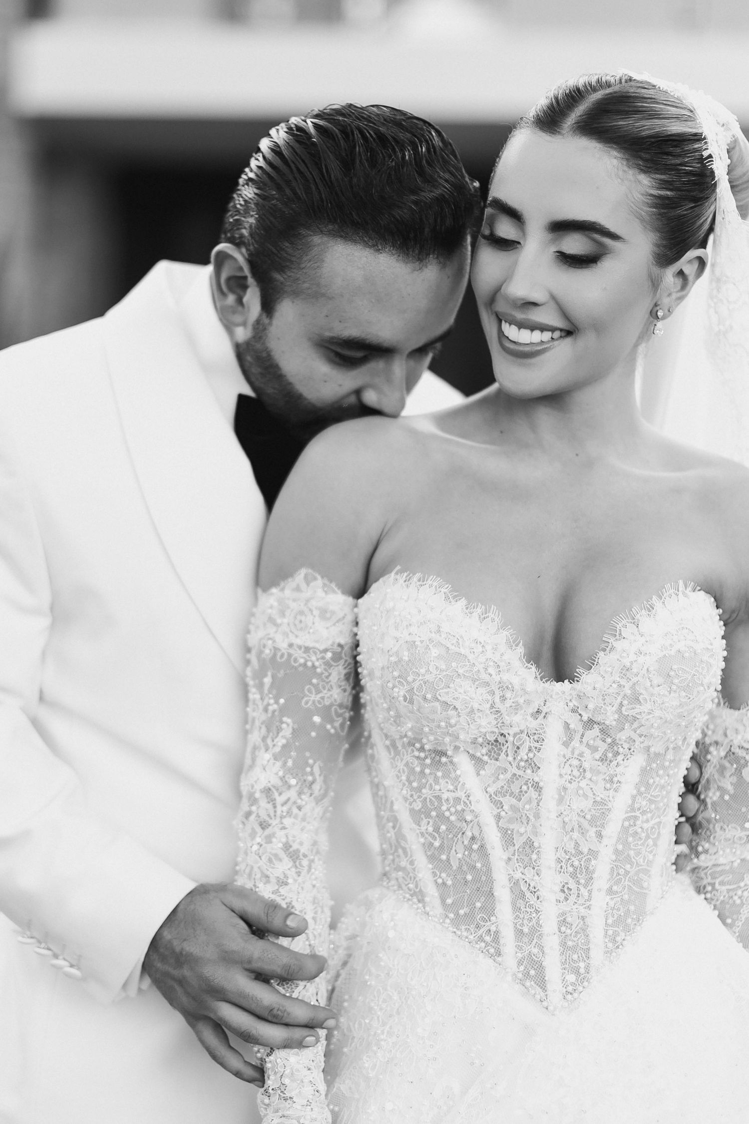 A series of intimate black and white wedding photos showing tender moments between a couple in elegant attire.