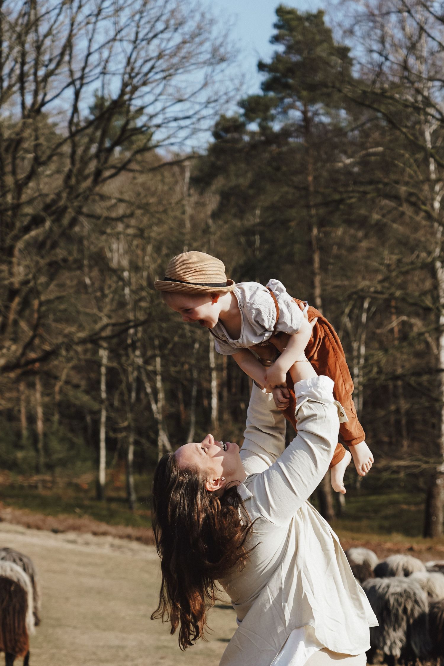 Joyful outdoor moment with lifting and spinning against a forest backdrop.