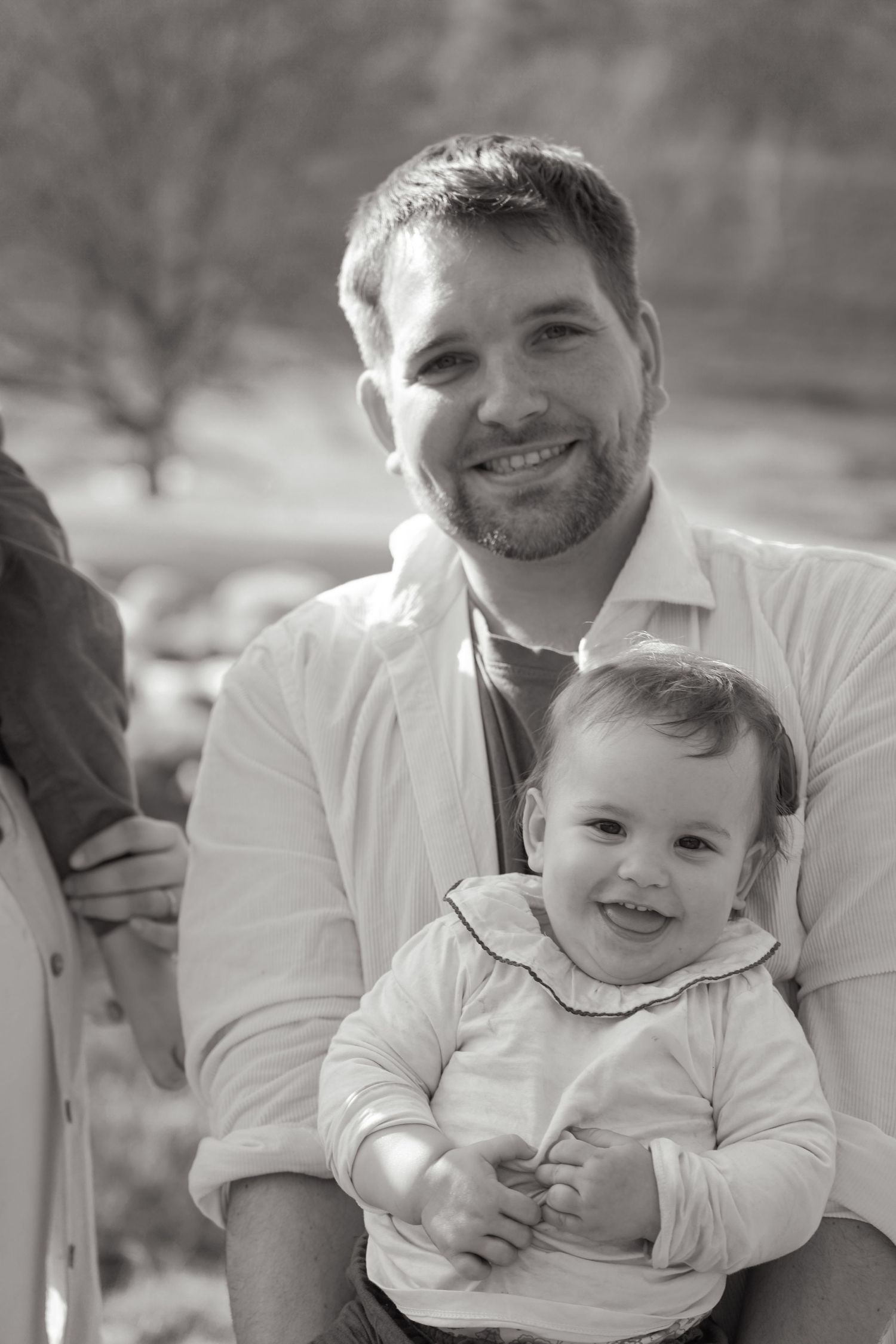 A heartwarming black and white portrait capturing a tender parent-child moment outdoors.