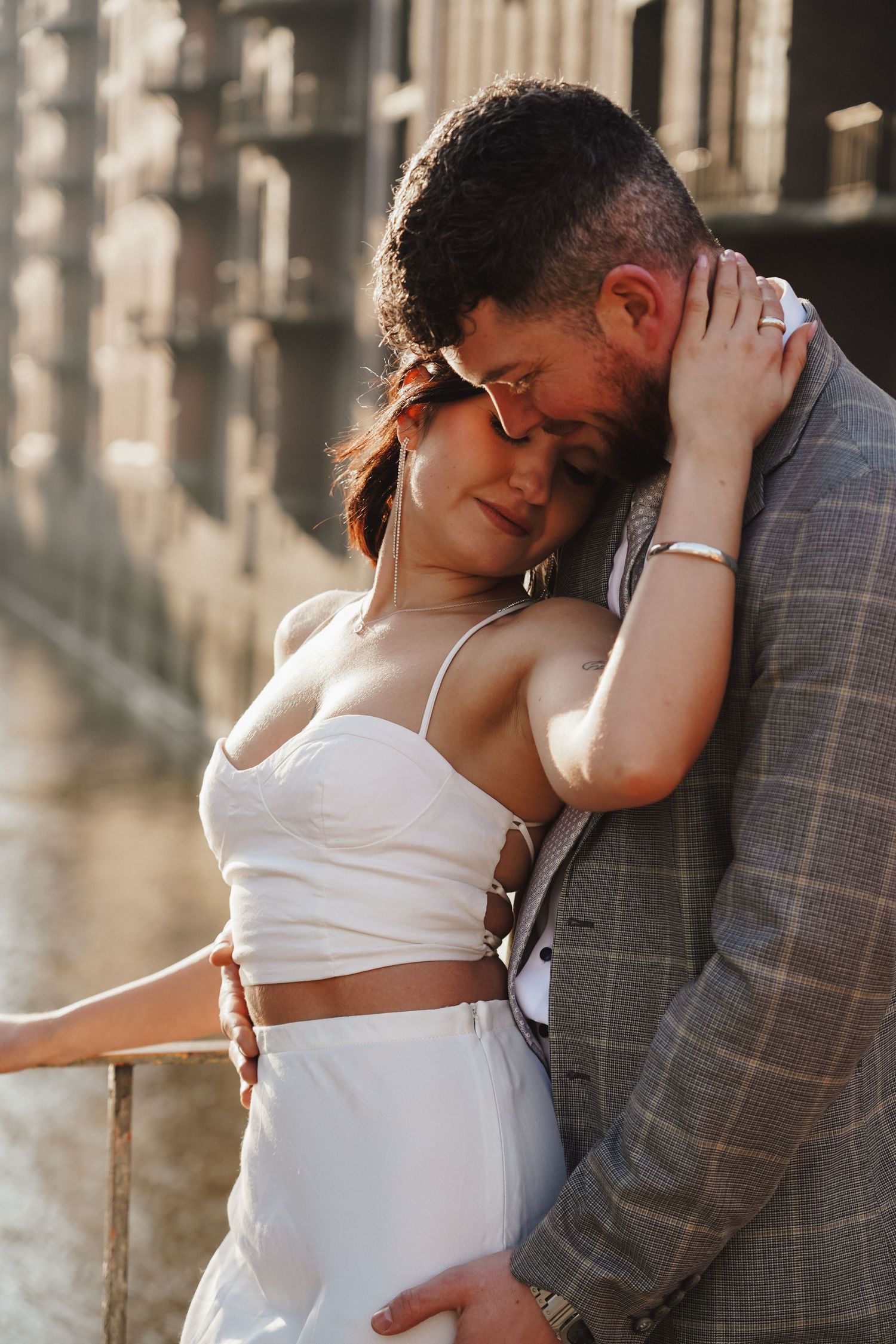 An intimate moment between a couple sharing a tender embrace in golden sunlight.