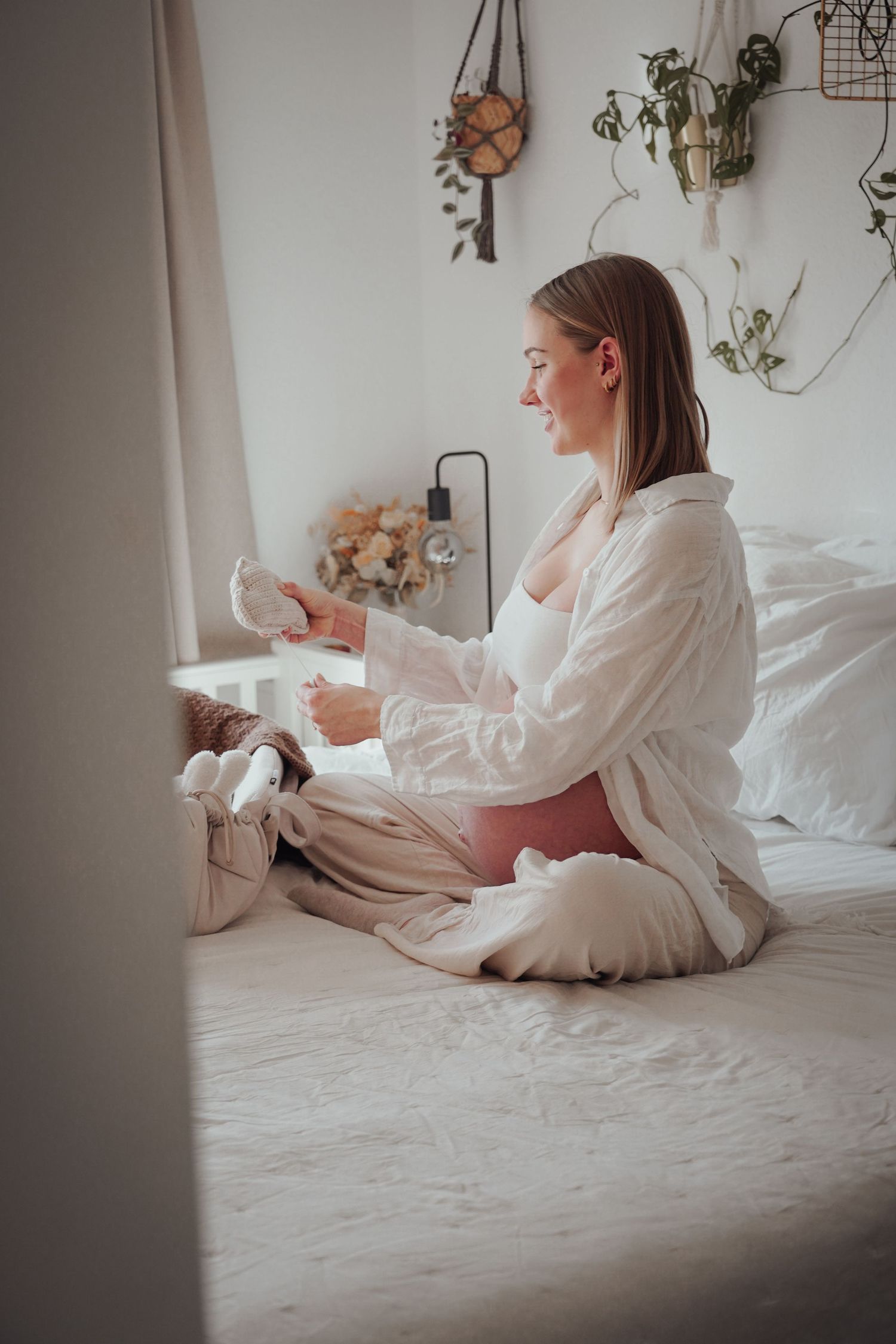 Peaceful morning scene of someone relaxing on a white bed wearing a cozy button-down shirt.