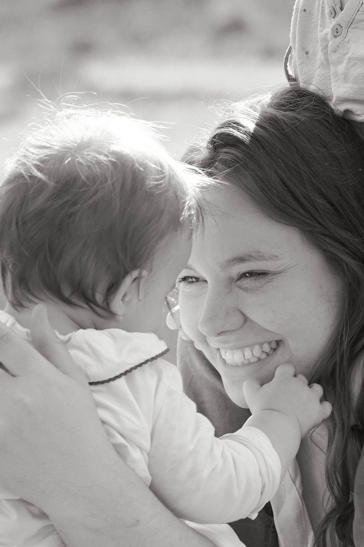 A tender black and white portrait of a mother and baby sharing a joyful moment together.