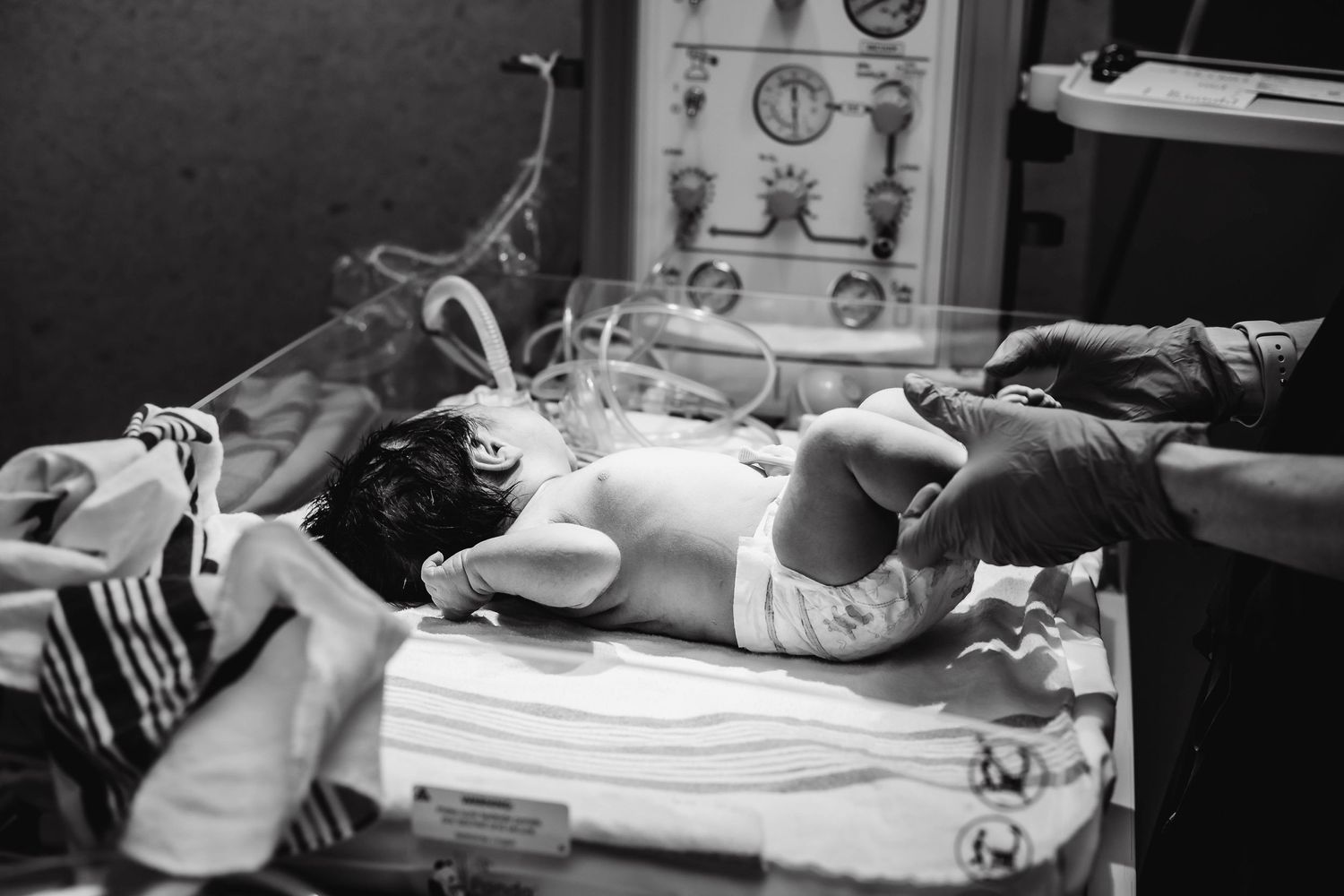 newborn checks being done on newborn warmer