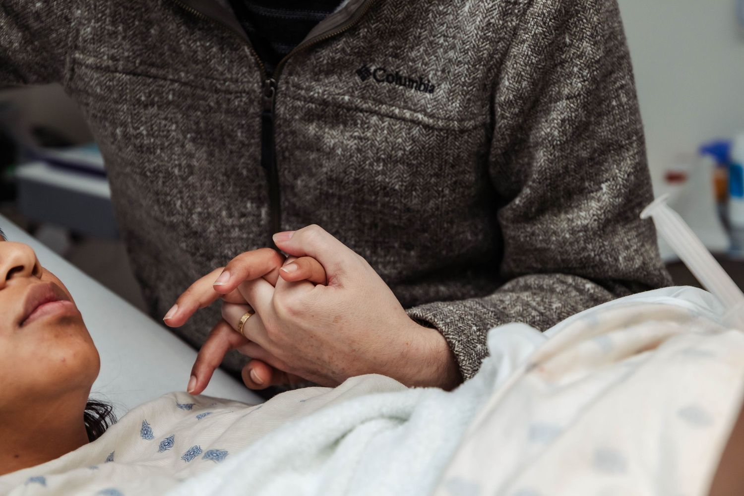 Husband holds wife's hand during labor