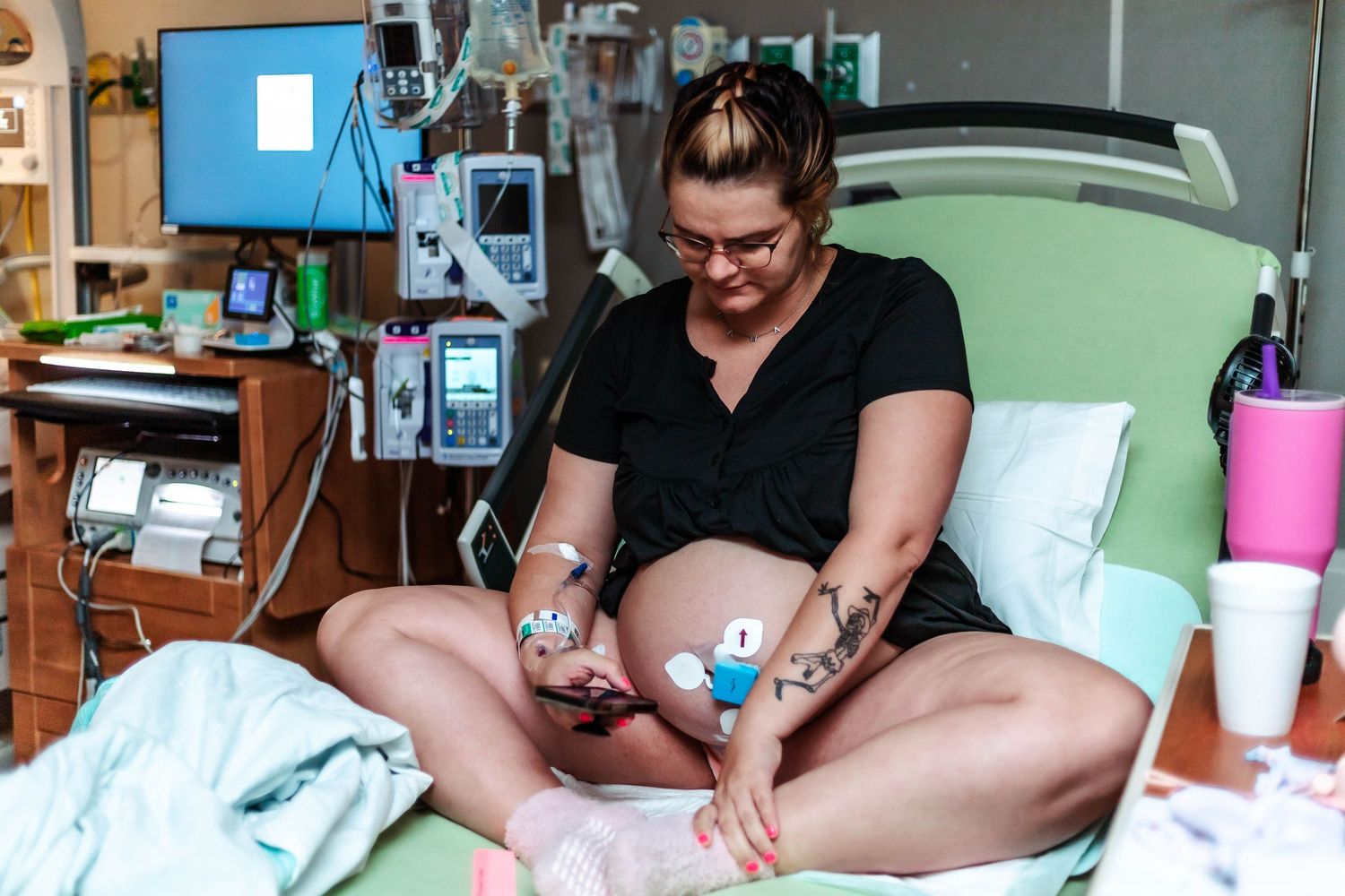 Laboring mother sits in butterfly position during delivery on her phone