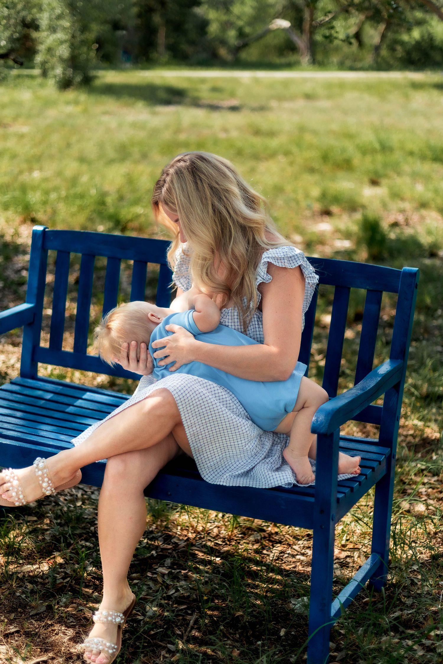 Mother nurses her son on a bench outside for breastfeeding sessions