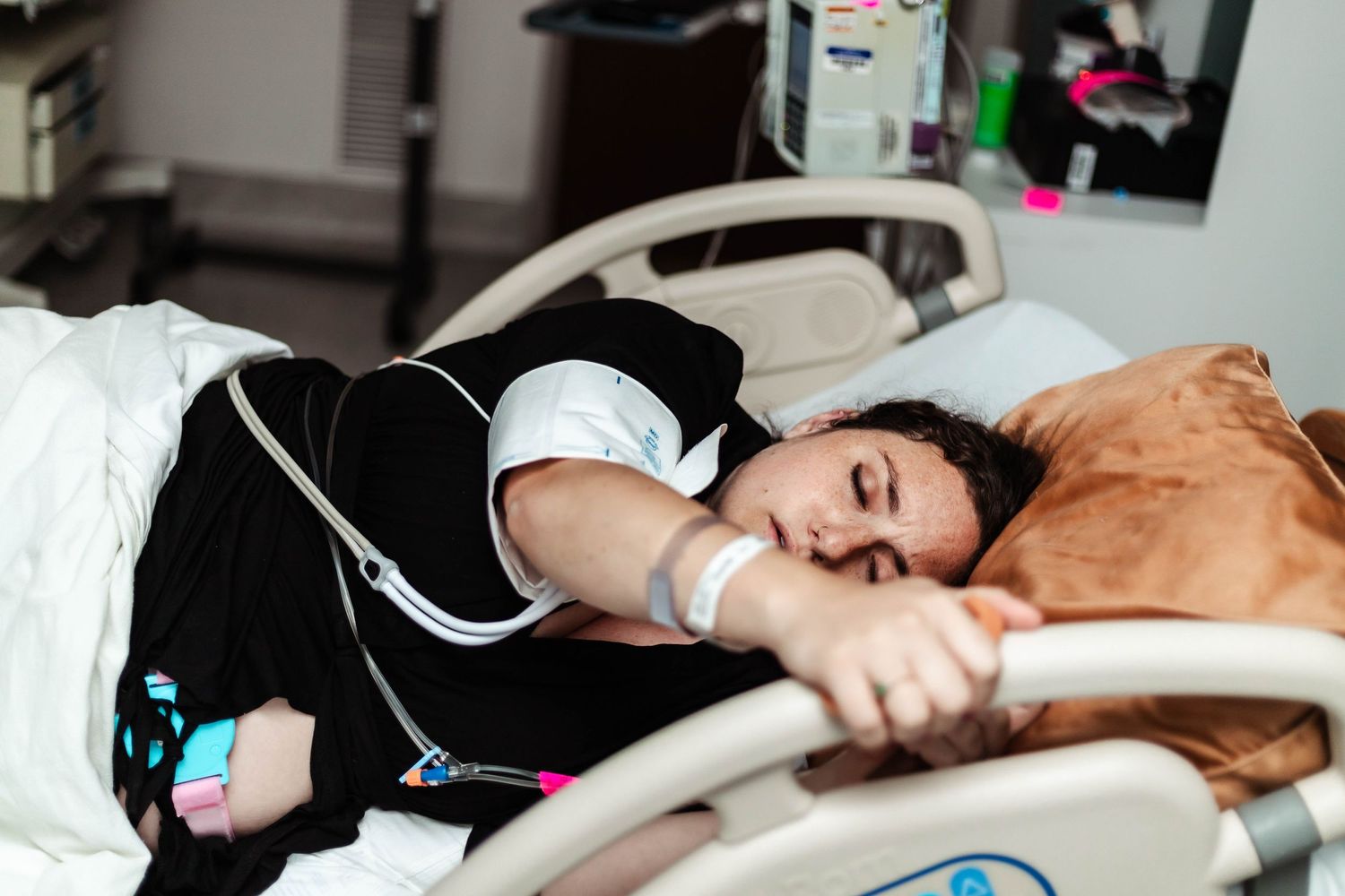 Laboring mother grabs the bedrails to breathe through contractions
