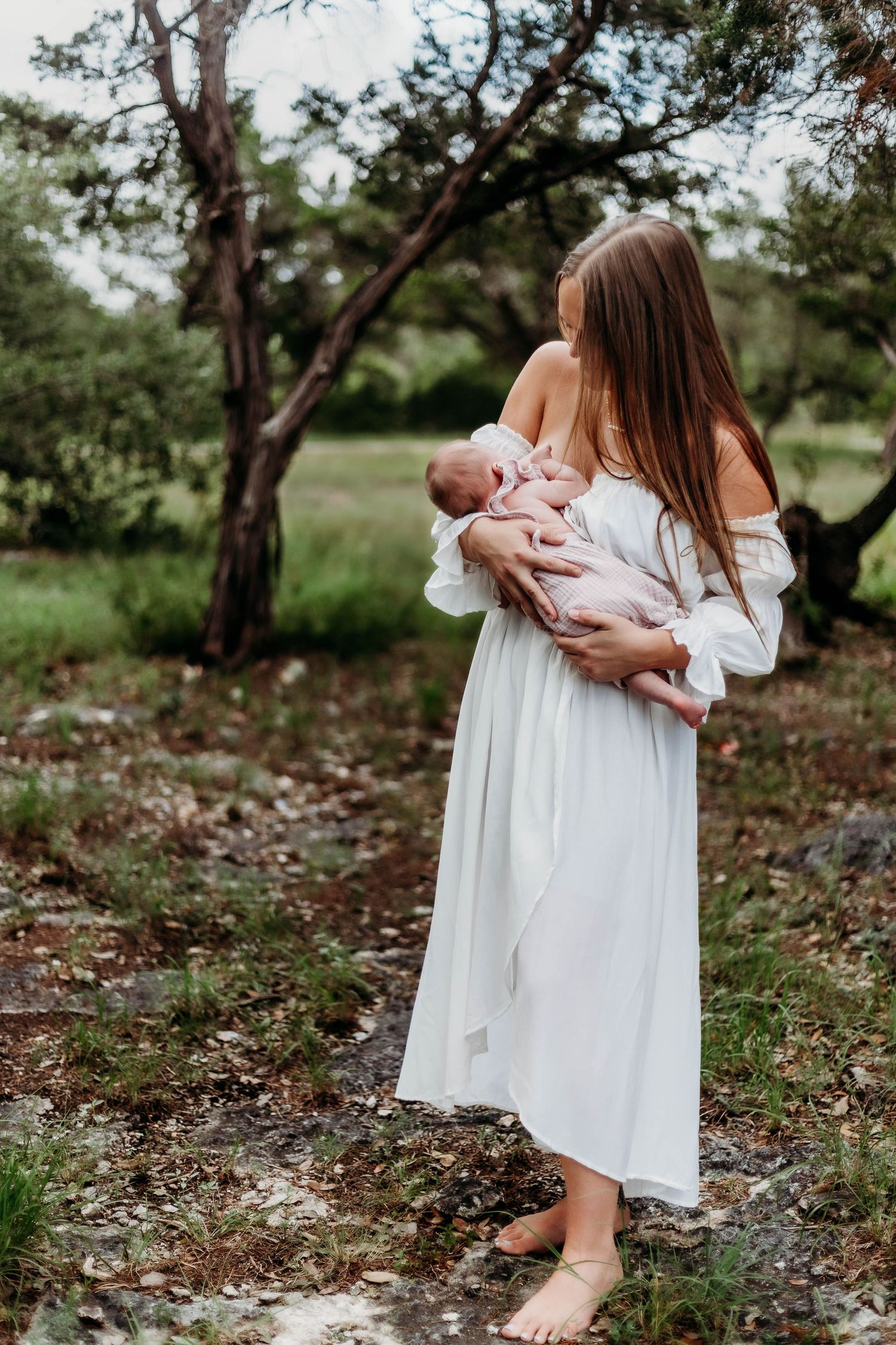 Mother nurses newborn baby in park at breastfeeding sessions