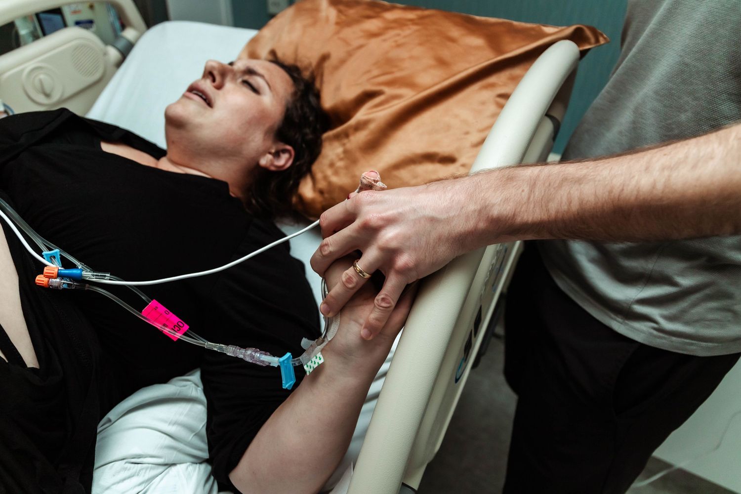 Husband holds wife hand right before delivery