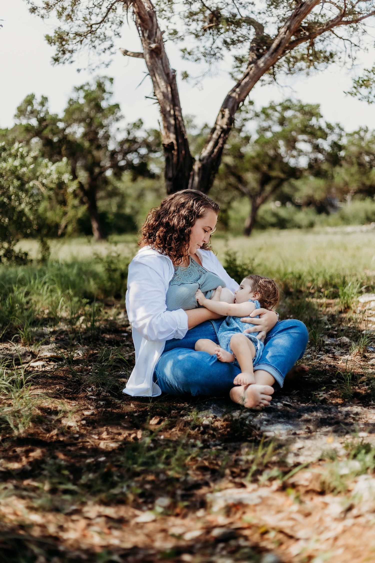 Mother nurses little one outside during free session